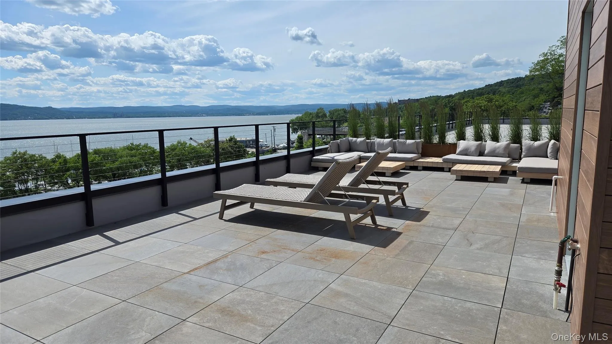 Expansive open-air terrace with plush sectional seating and panoramic views up the river. Expansive open-air terrace with plush sectional seating and panoramic views up the river.