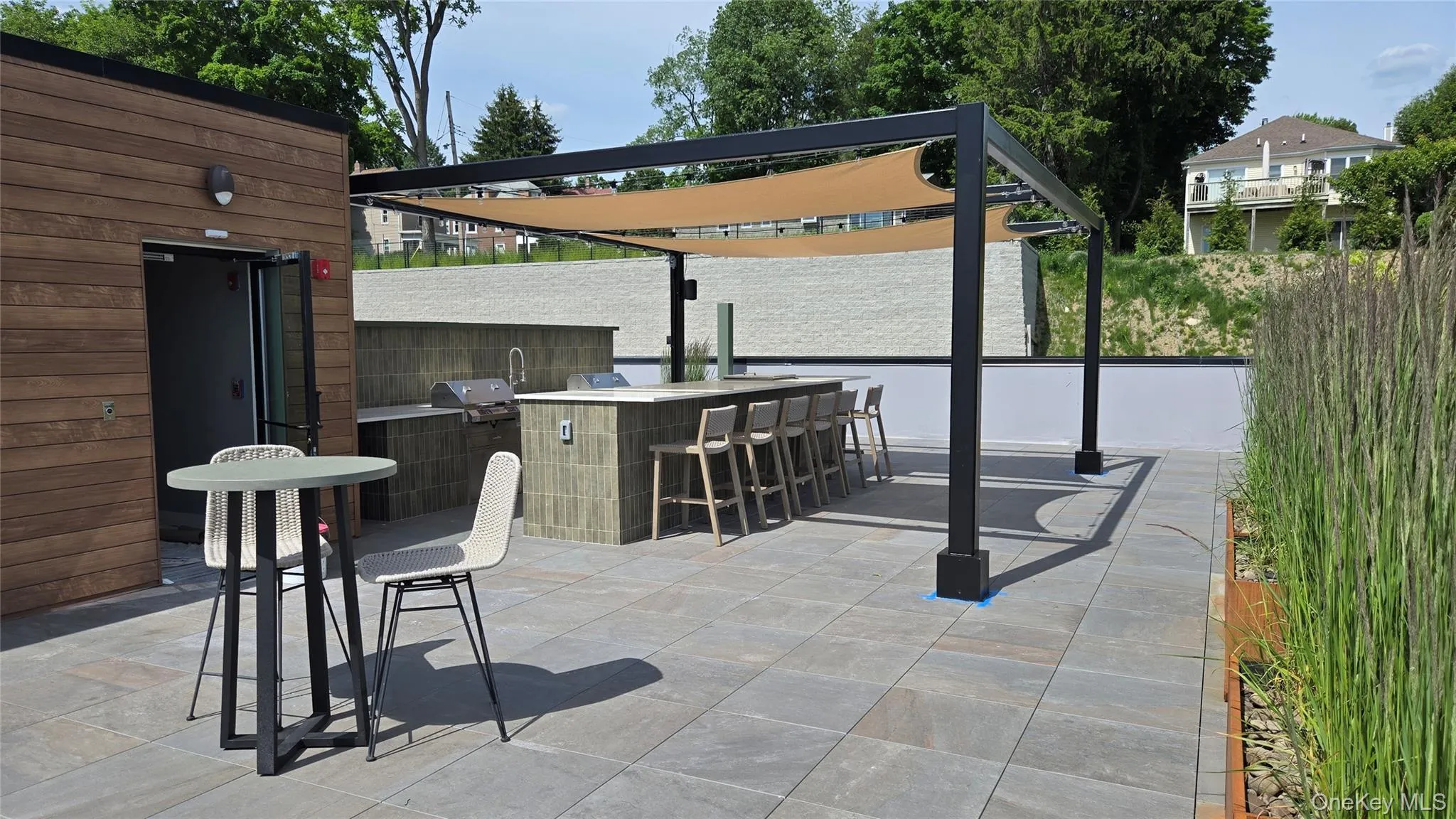 The rooftop kitchen features dual grills, a prep sink, and bar seating for entertaining. The rooftop kitchen features dual grills, a prep sink, and bar seating for entertaining.
