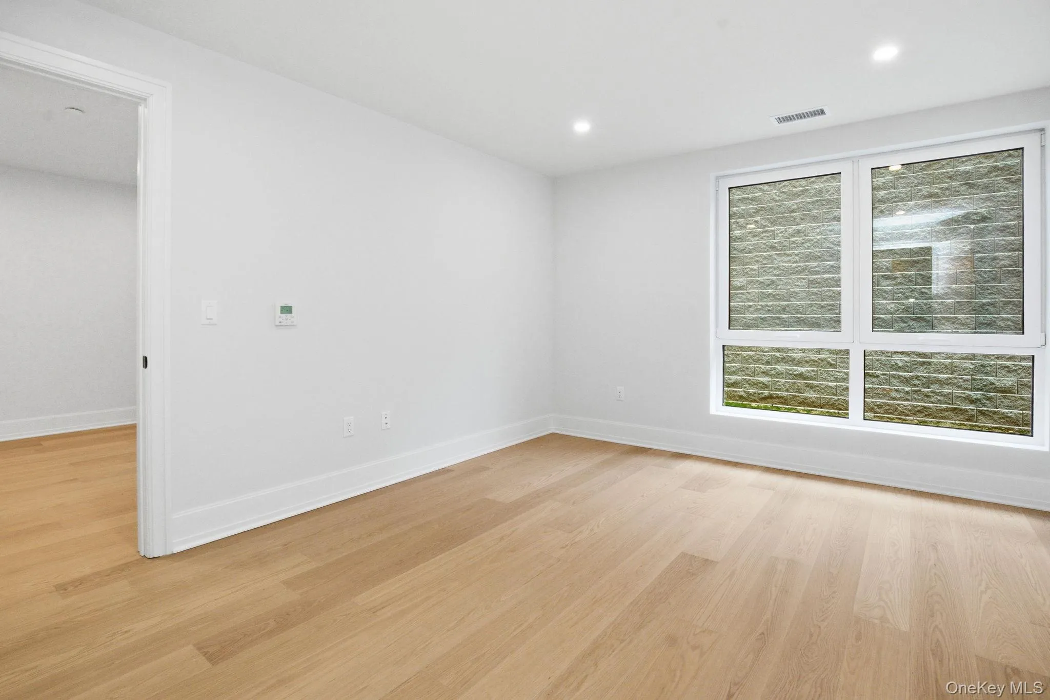 Light-filled bedroom featuring oversized windows that invite natural light while maintaining a calm and private atmosphere. Light-filled bedroom featuring oversized windows that invite natural light while maintaining a calm and private atmosphere.
