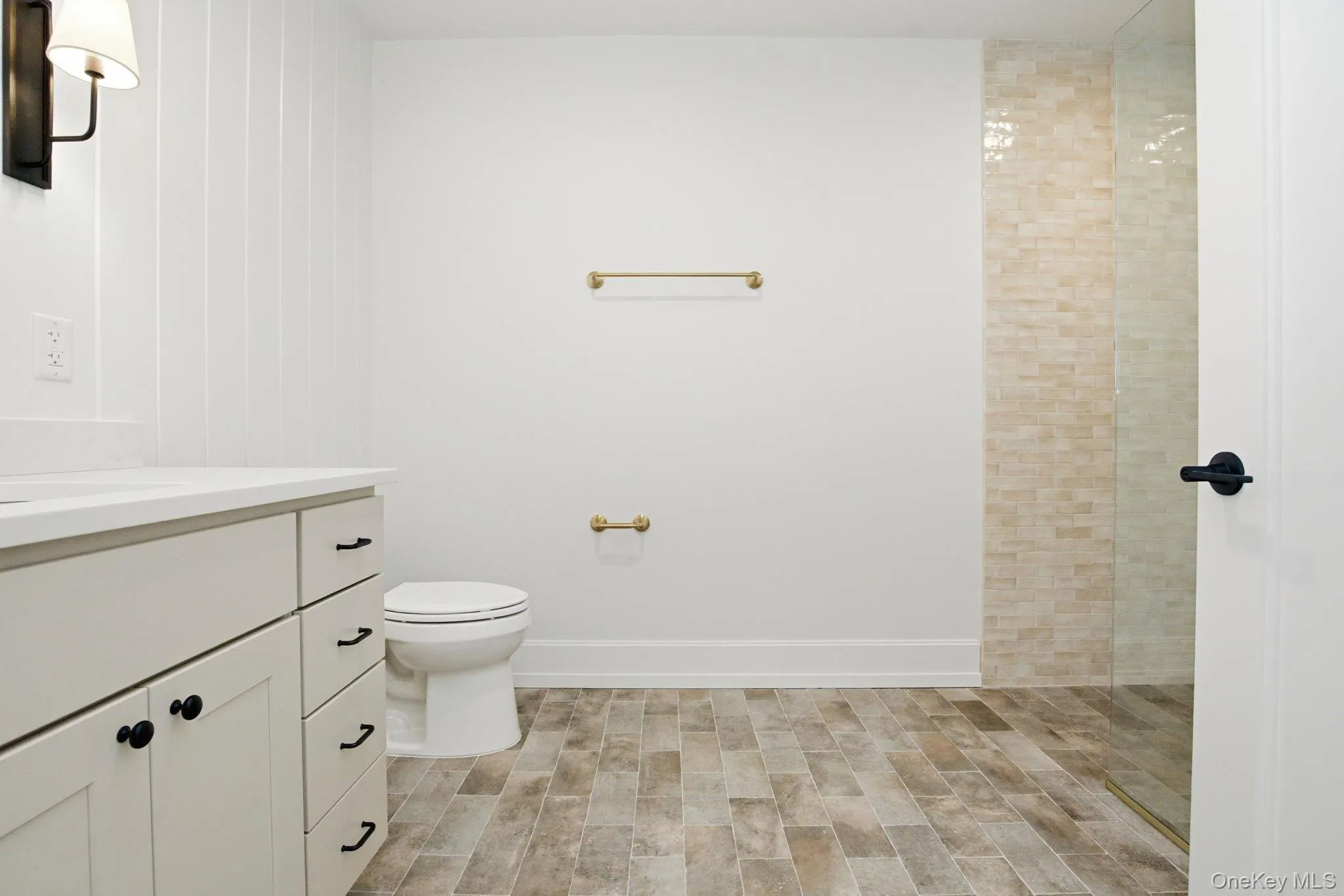 Spacious bathroom offering a zero-entry shower with tile surround and a cohesive blend of warm and contemporary materials. Spacious bathroom offering a zero-entry shower with tile surround and a cohesive blend of warm and contemporary materials.