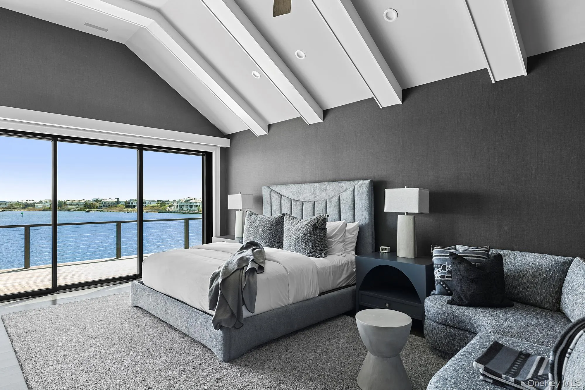 Bedroom with access to exterior, high vaulted ceiling, and a water view Bedroom with access to exterior, high vaulted ceiling, and a water view