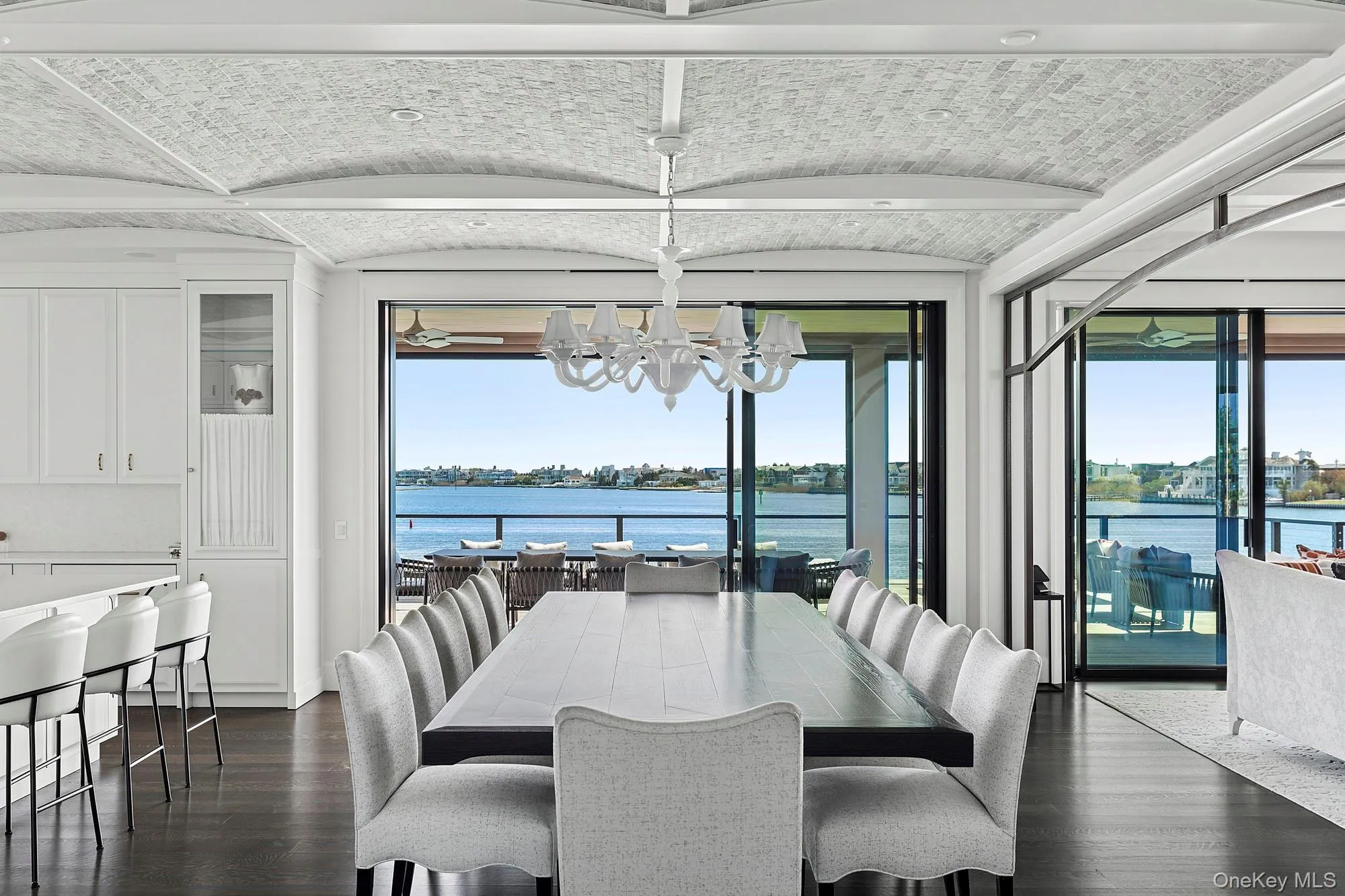 Dining space with a chandelier, dark wood-style flooring, a water view, and plenty of natural light Dining space with a chandelier, dark wood-style flooring, a water view, and plenty of natural light