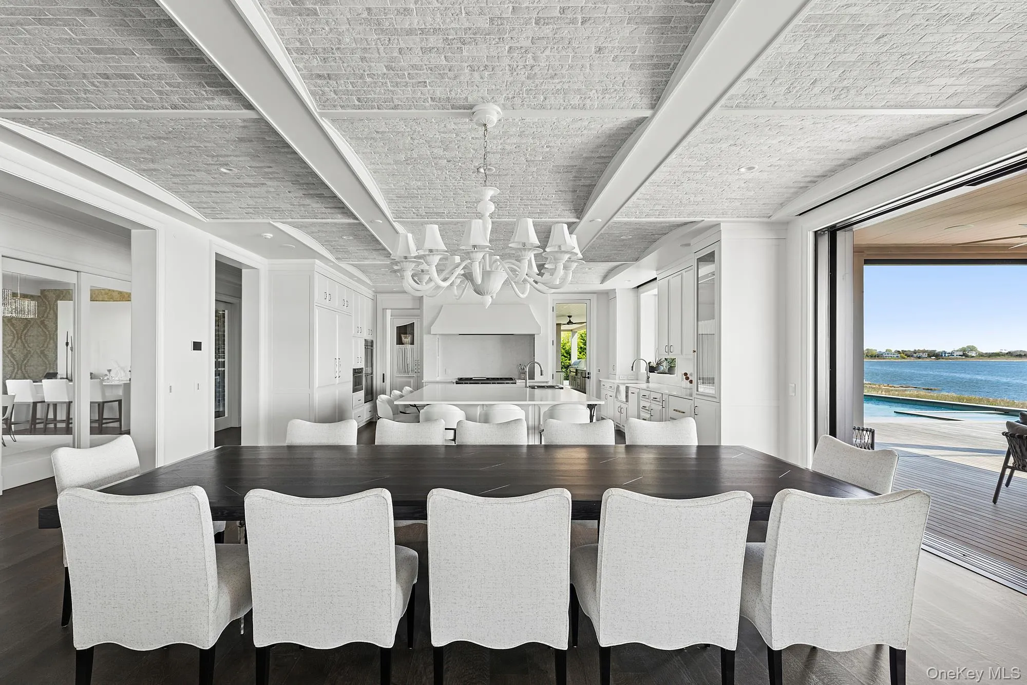 Kitchen featuring a center island with sink, wood finished floors, a chandelier, and white cabinetry Kitchen featuring a center island with sink, wood finished floors, a chandelier, and white cabinetry