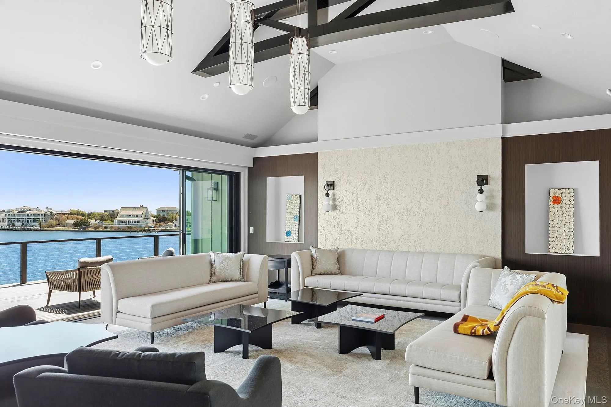 Carpeted living area with high vaulted ceiling, a water view, and recessed lighting Carpeted living area with high vaulted ceiling, a water view, and recessed lighting