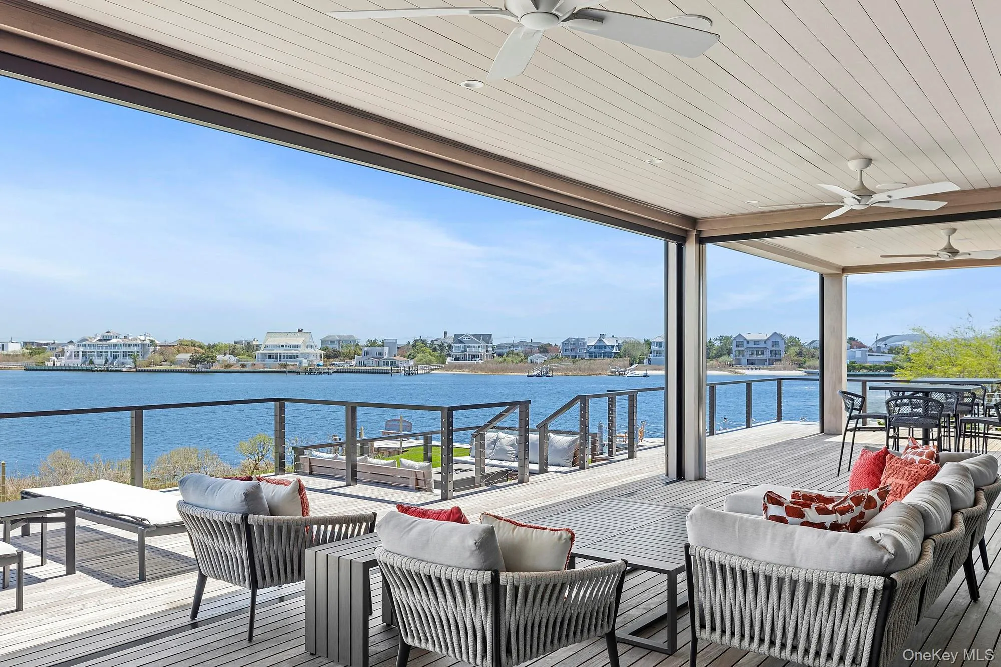 Wooden deck with an outdoor hangout area, a ceiling fan, and a water view Wooden deck with an outdoor hangout area, a ceiling fan, and a water view