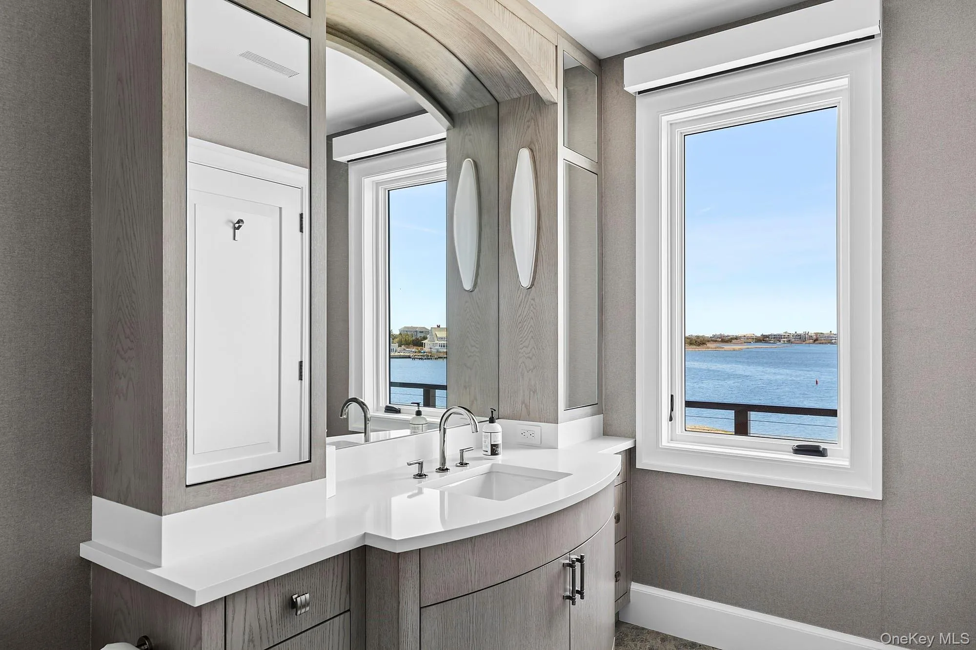 Bathroom with a water view, vanity, and baseboards Bathroom with a water view, vanity, and baseboards