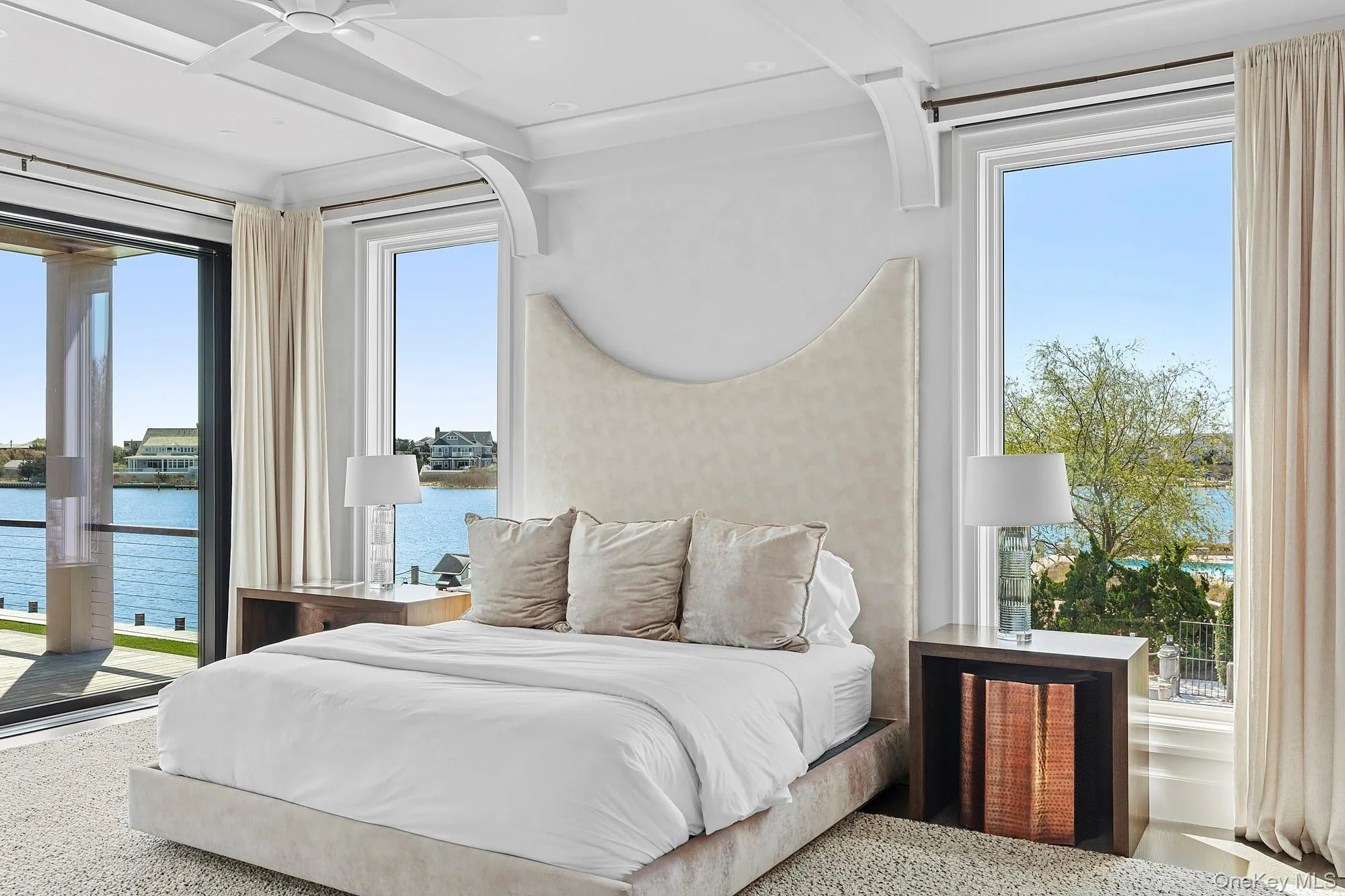Bedroom with a water view, access to outside, beamed ceiling, and speckle patterned floor Bedroom with a water view, access to outside, beamed ceiling, and speckle patterned floor