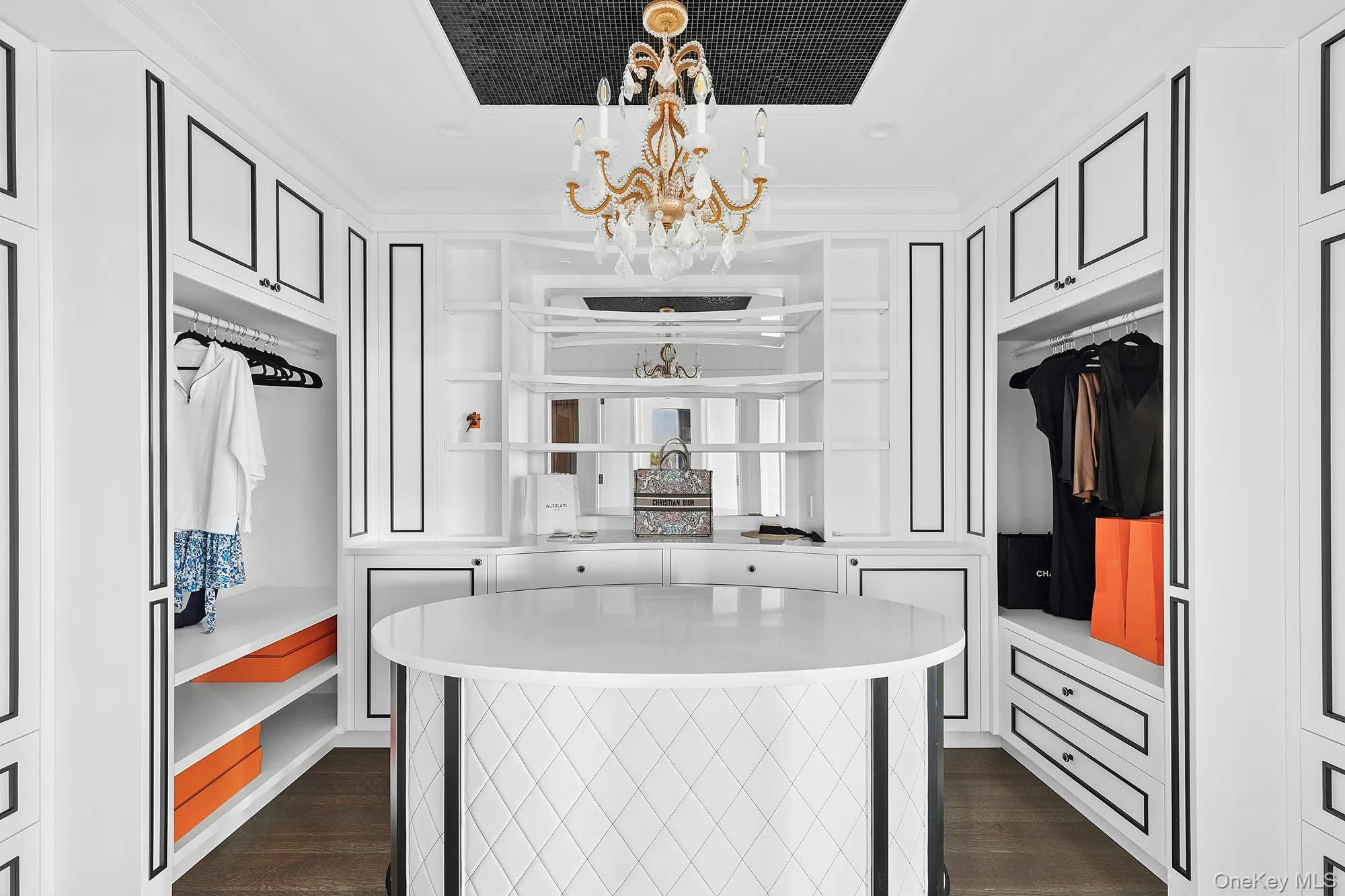 Walk in closet with a chandelier and dark wood-style floors Walk in closet with a chandelier and dark wood-style floors