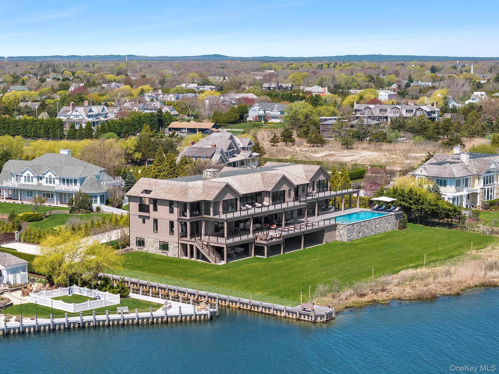 Aerial perspective of suburban area featuring a large body of water and a pool Aerial perspective of suburban area featuring a large body of water and a pool