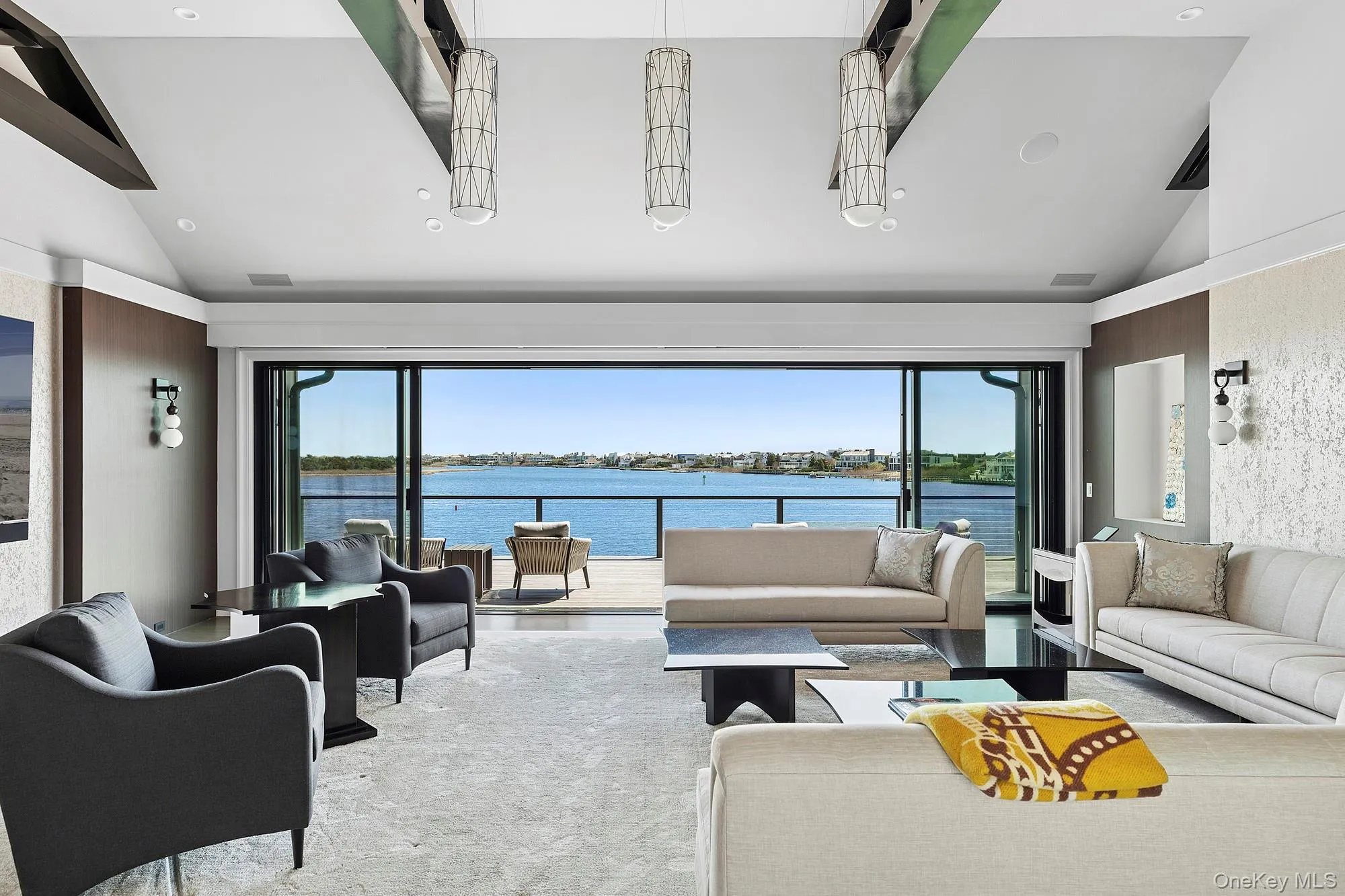 Living room with high vaulted ceiling, a water view, carpet floors, and recessed lighting Living room with high vaulted ceiling, a water view, carpet floors, and recessed lighting