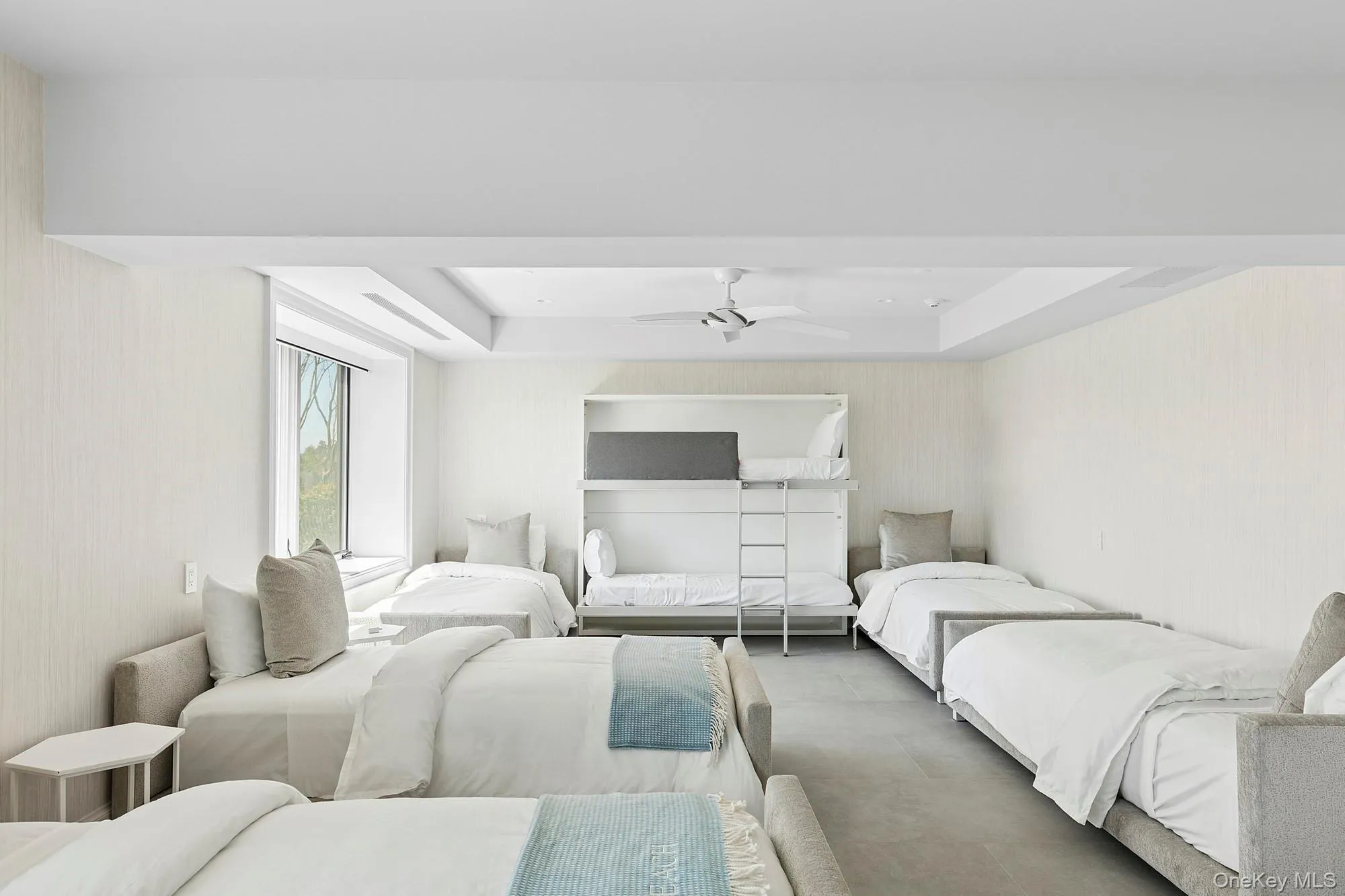 Bedroom with ceiling fan, a raised ceiling, and wallpapered walls Bedroom with ceiling fan, a raised ceiling, and wallpapered walls