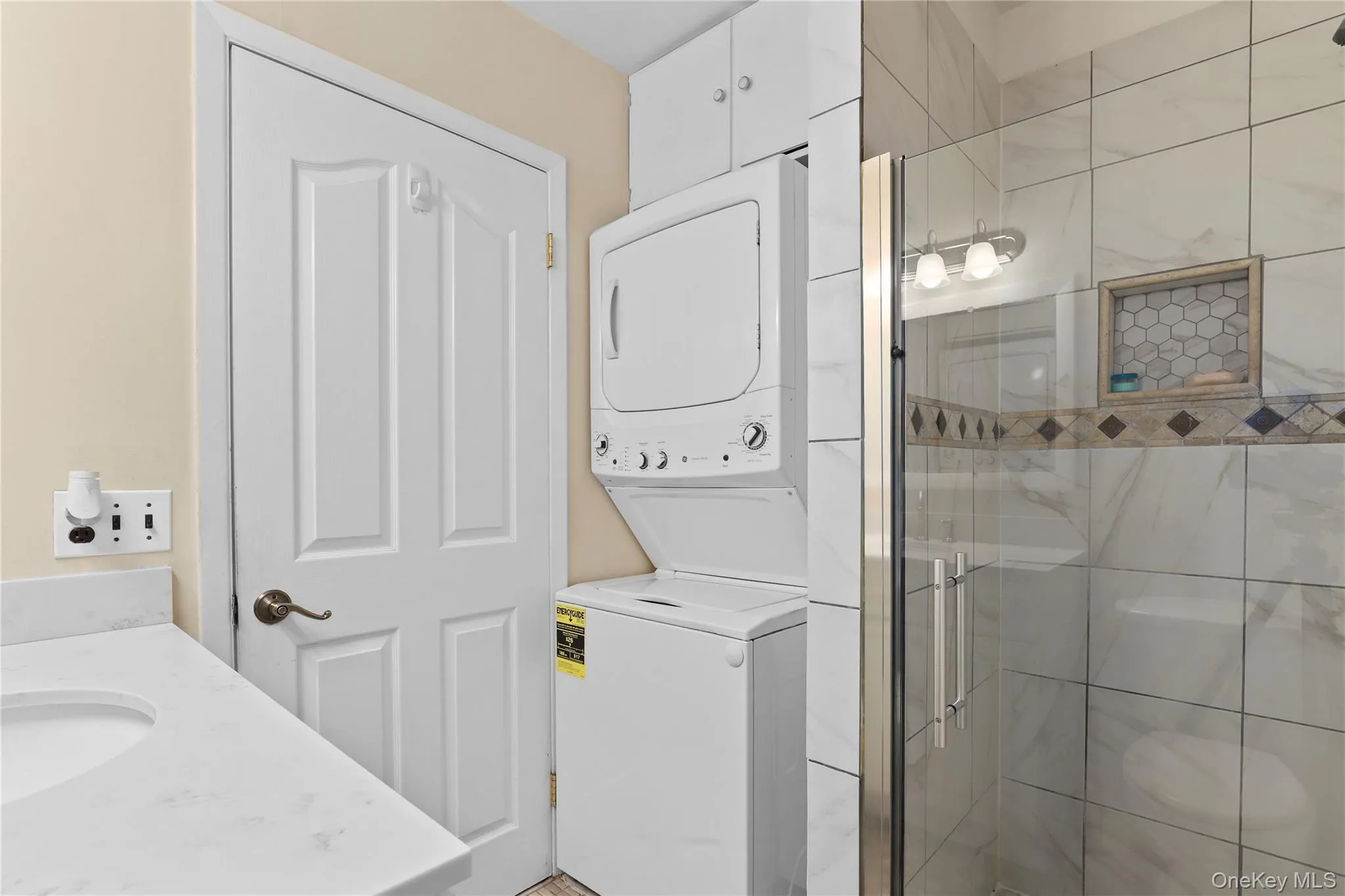Hall bath. Beautiful tilework in the walk-in shower. Stackable washer and dryer updated in (2024). Hall bath. Beautiful tilework in the walk-in shower. Stackable washer and dryer updated in (2024).