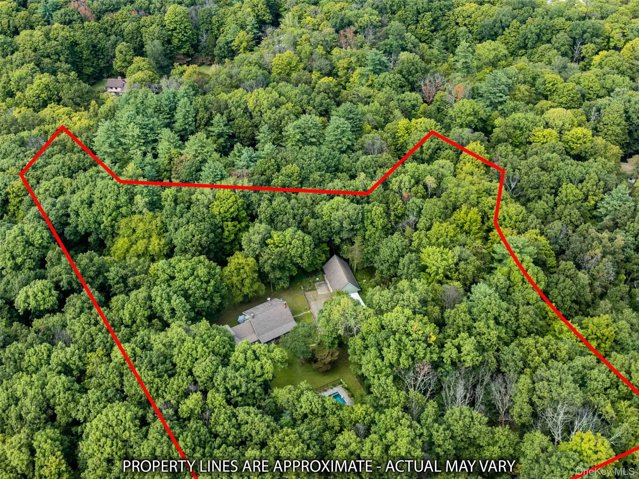 Aerial view of property and surrounding area with property boundaries highlighted and a heavily wooded area Aerial view of property and surrounding area with property boundaries highlighted and a heavily wooded area