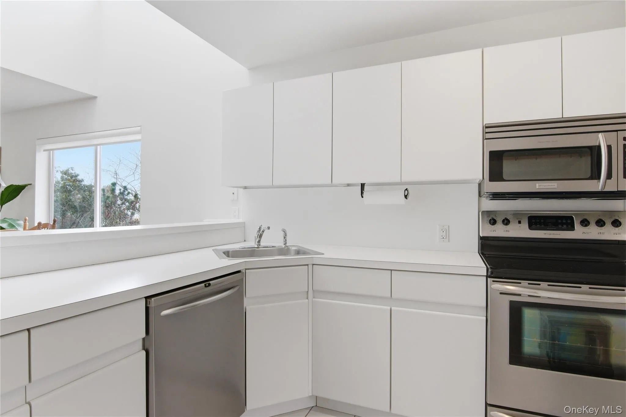 Kitchen with stainless steel appliances, light countertops, and white cabinets Kitchen with stainless steel appliances, light countertops, and white cabinets