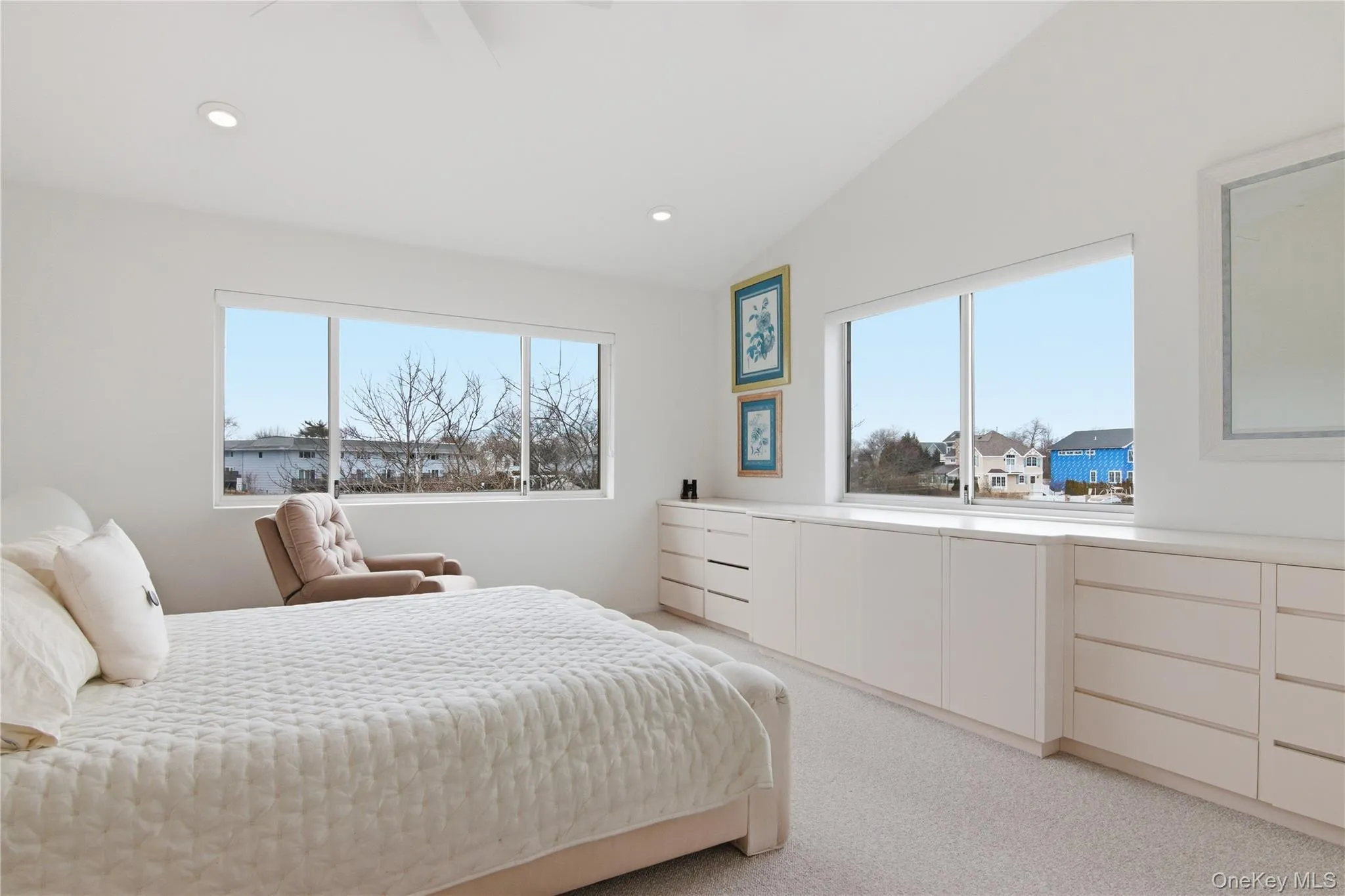 Bedroom with multiple windows, lofted ceiling, light carpet, a ceiling fan, and recessed lighting Bedroom with multiple windows, lofted ceiling, light carpet, a ceiling fan, and recessed lighting