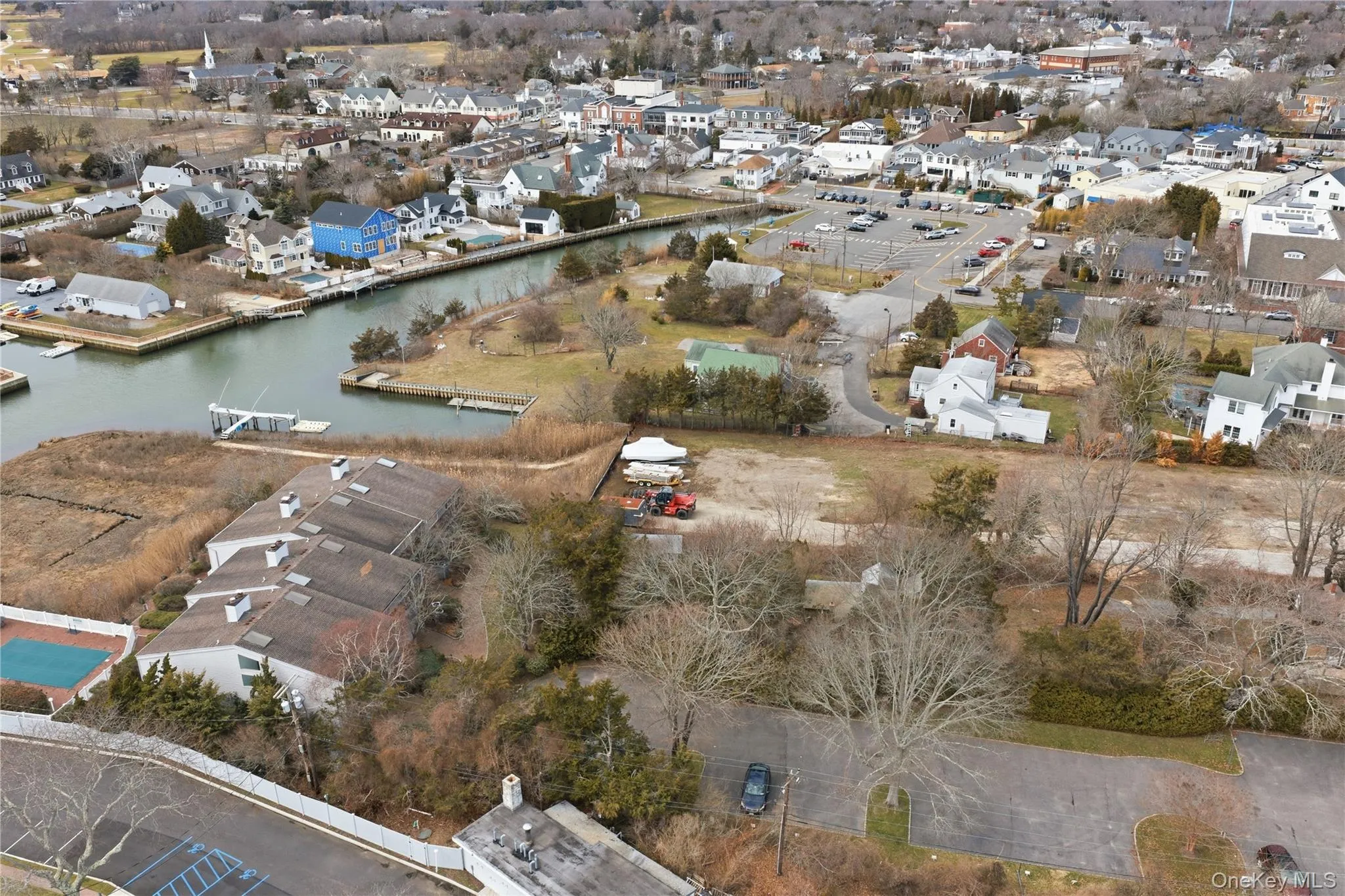 Aerial view of property's location featuring nearby village and water Aerial view of property's location featuring nearby village and water