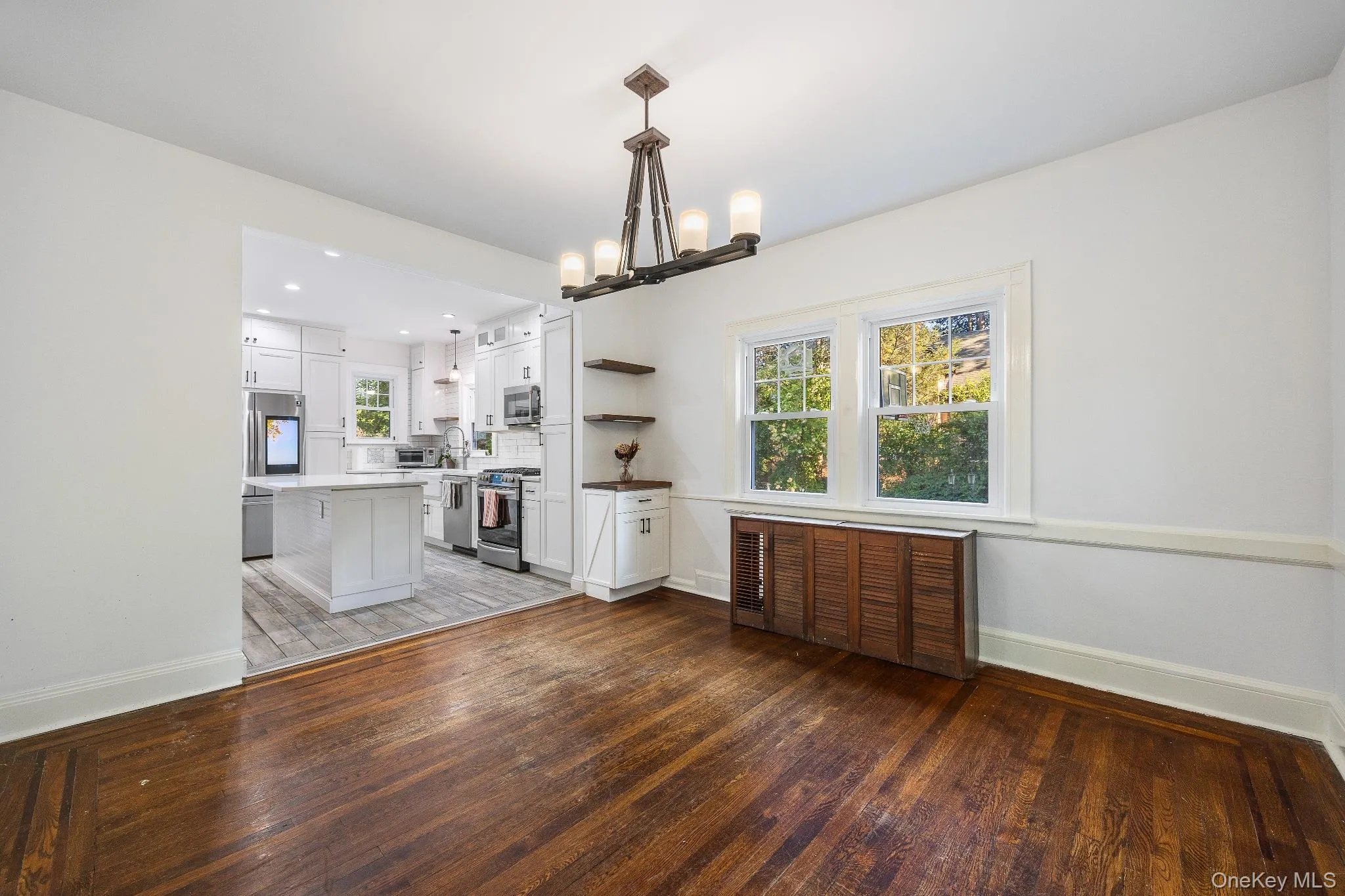 Kitchen featuring white cabinetry, dark wood-style flooring, open shelves, and hanging light fixtures Kitchen featuring white cabinetry, dark wood-style flooring, open shelves, and hanging light fixtures