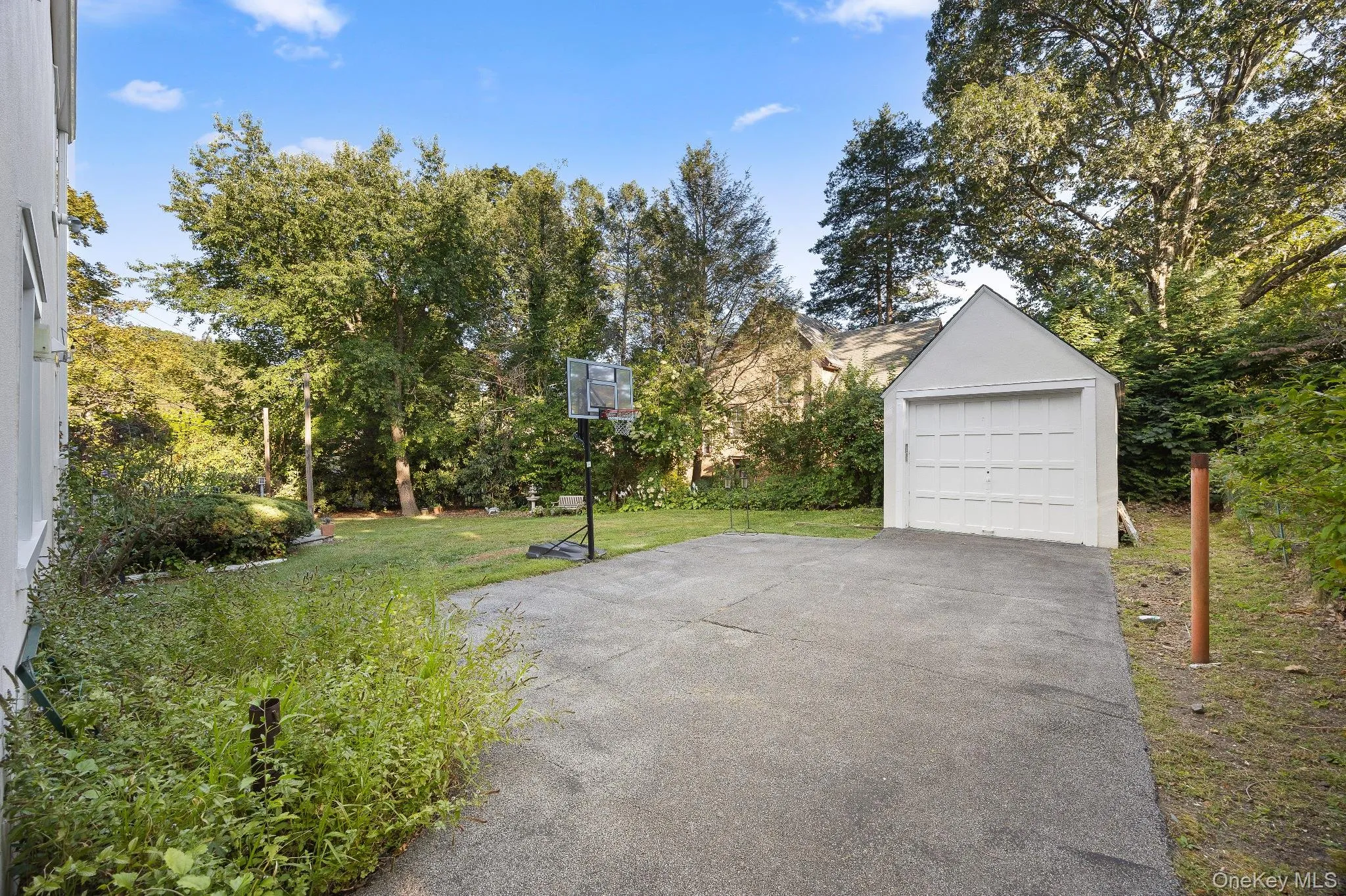 View of patio with driveway, an outbuilding, and a garage View of patio with driveway, an outbuilding, and a garage