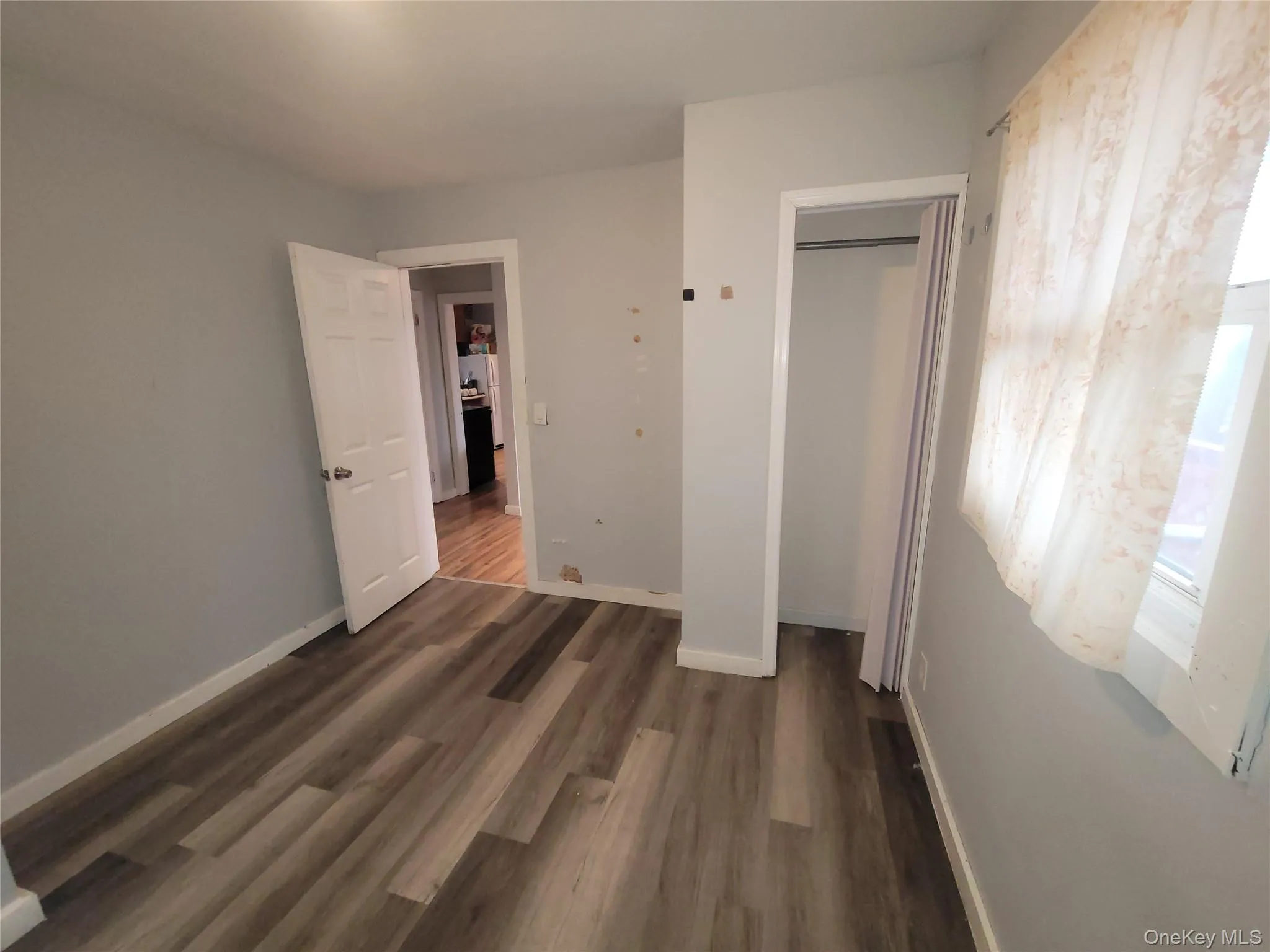 Light gray painted walls with white trim and wood-finish flooring Light gray painted walls with white trim and wood-finish flooring