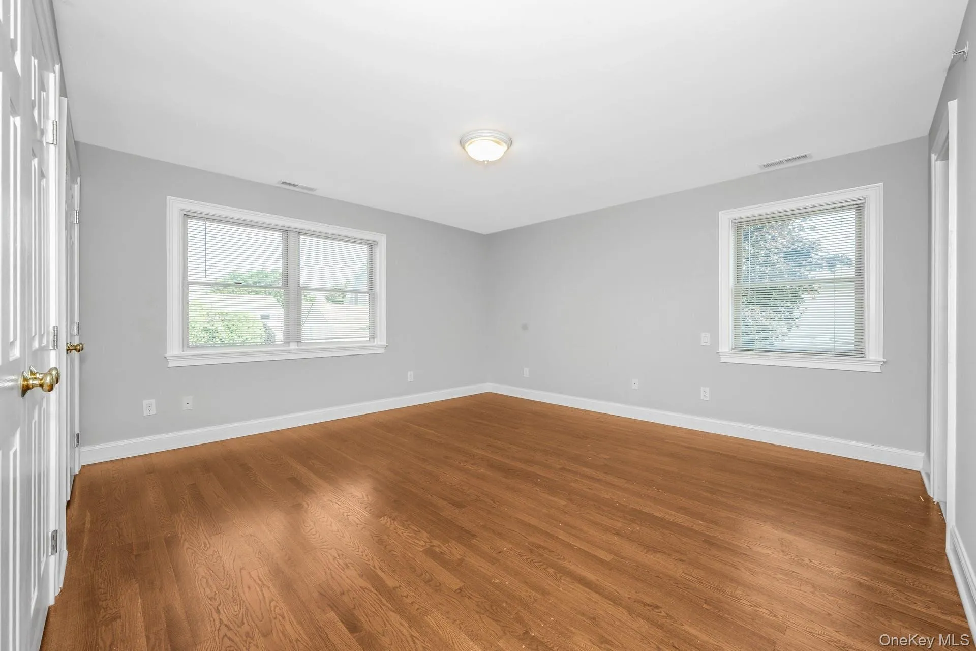 Unfurnished room with plenty of natural light and wood finished floors Unfurnished room with plenty of natural light and wood finished floors