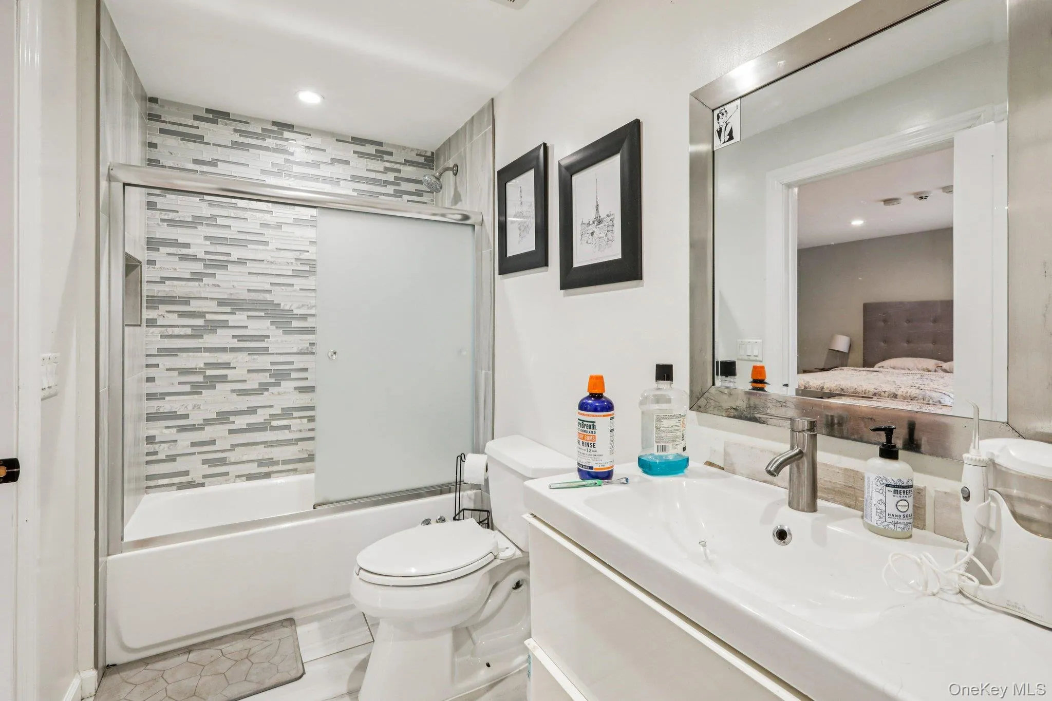 Bathroom with vanity, shower / bath combination with glass door, ensuite bath, and recessed lighting Bathroom with vanity, shower / bath combination with glass door, ensuite bath, and recessed lighting