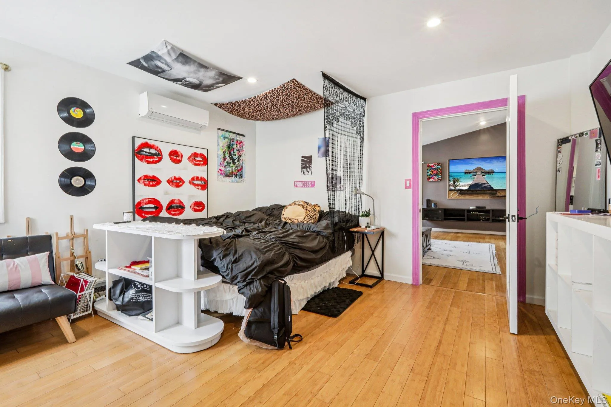 Bedroom with light wood-style floors, a wall mounted mini split, and recessed lighting Bedroom with light wood-style floors, a wall mounted mini split, and recessed lighting