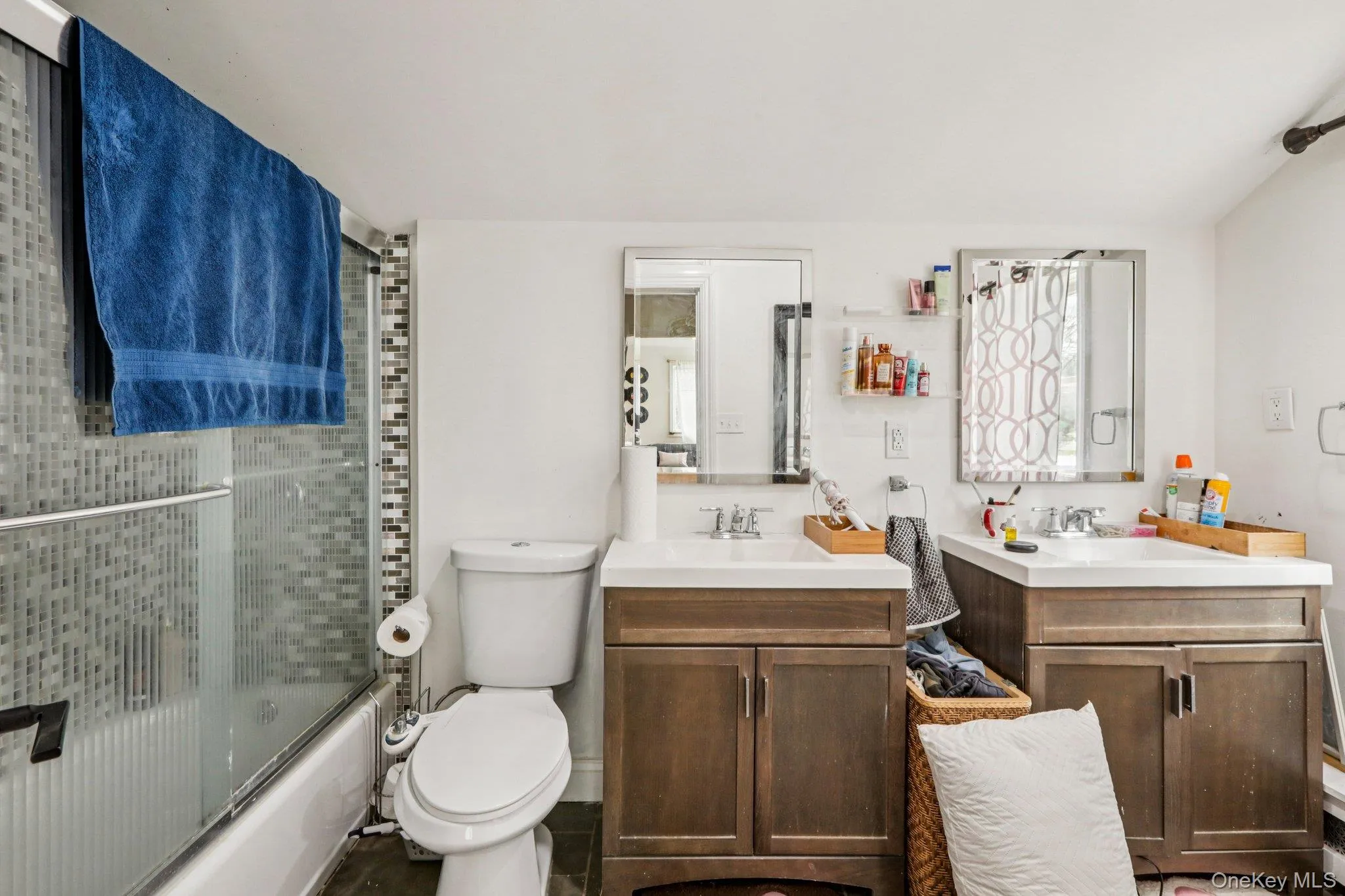 Full bath featuring two vanities and combined bath / shower with glass door Full bath featuring two vanities and combined bath / shower with glass door