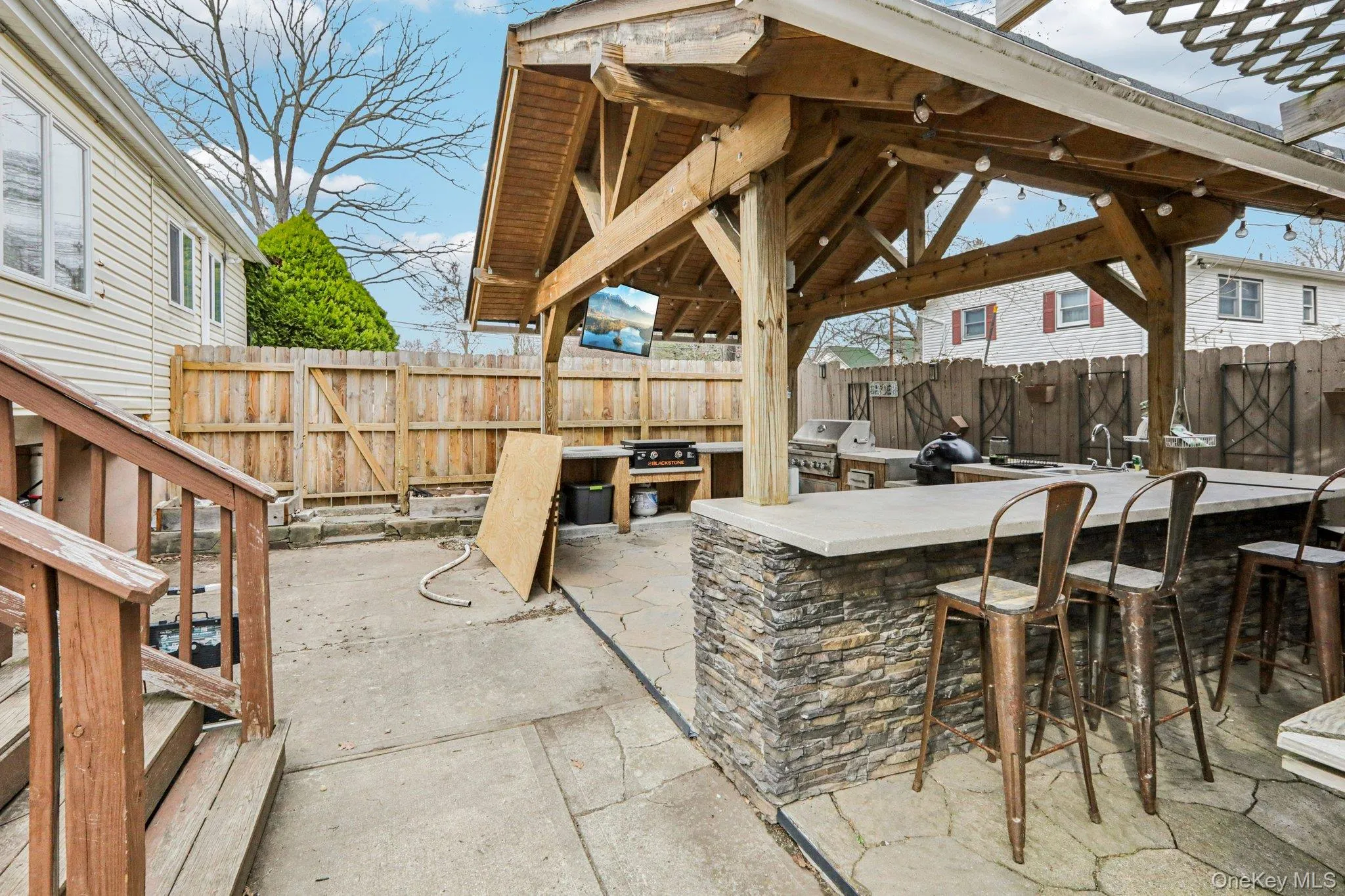 Fenced backyard featuring a patio area, exterior kitchen, and a gazebo Fenced backyard featuring a patio area, exterior kitchen, and a gazebo