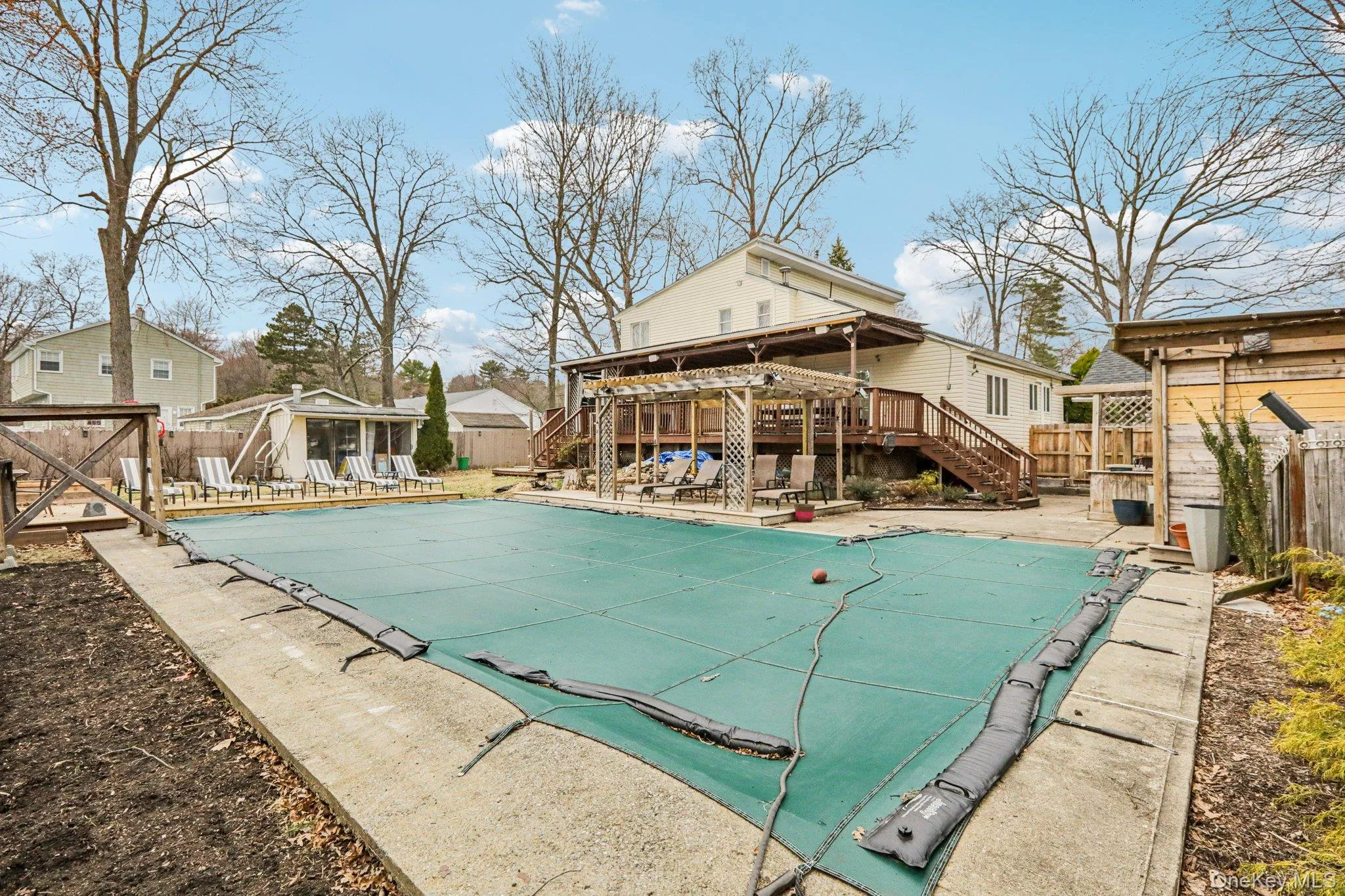 View of swimming pool with a fenced backyard, patio surround, and an outdoor structure View of swimming pool with a fenced backyard, patio surround, and an outdoor structure