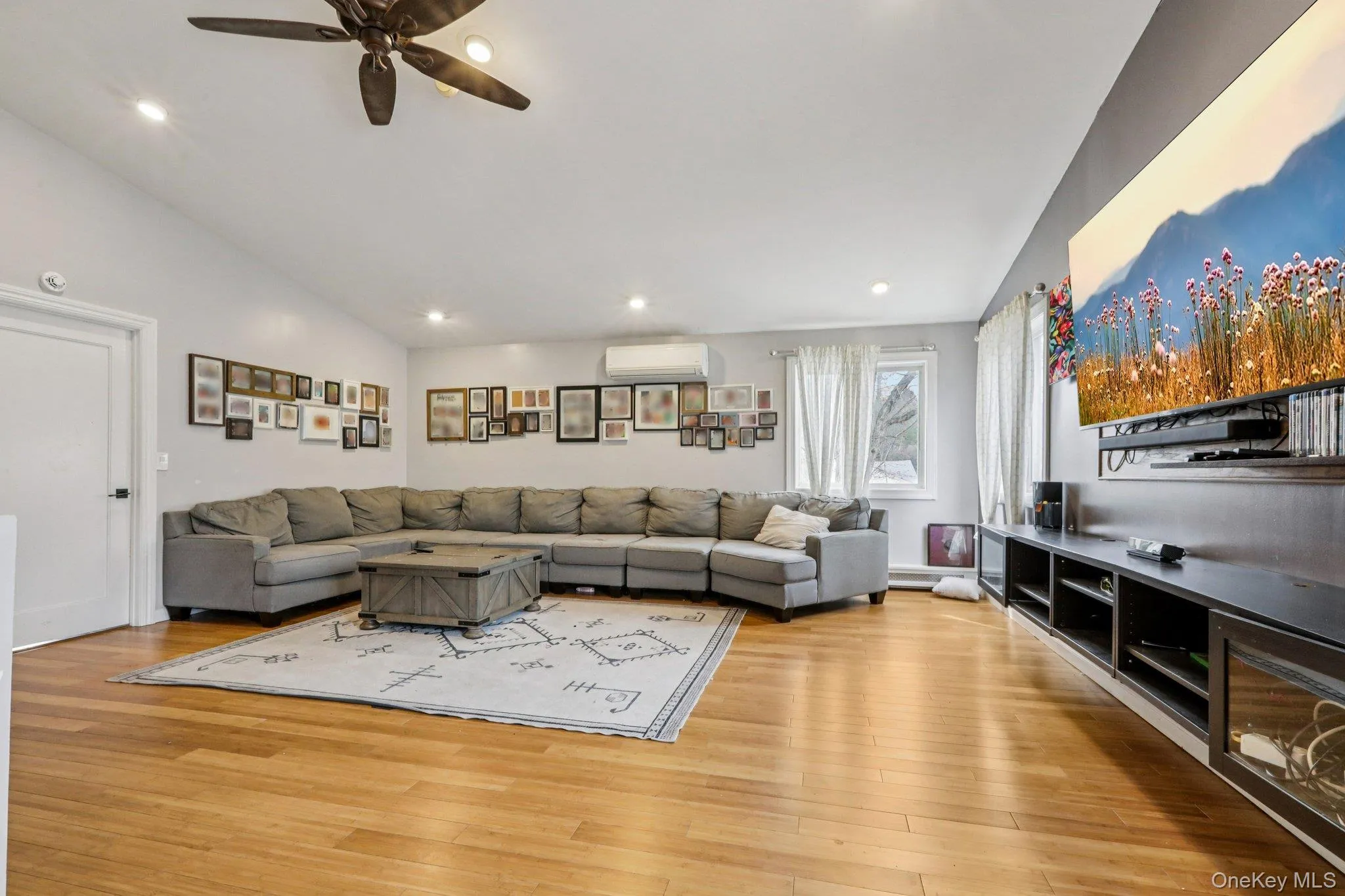 Living area with ceiling fan, light wood finished floors, vaulted ceiling, and recessed lighting Living area with ceiling fan, light wood finished floors, vaulted ceiling, and recessed lighting