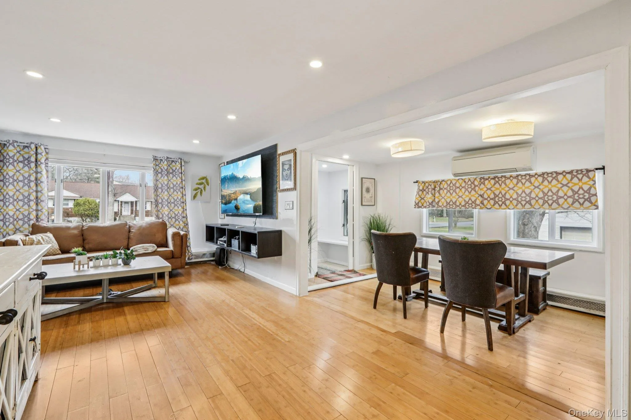 Living room featuring light wood finished floors, a baseboard radiator, and recessed lighting Living room featuring light wood finished floors, a baseboard radiator, and recessed lighting