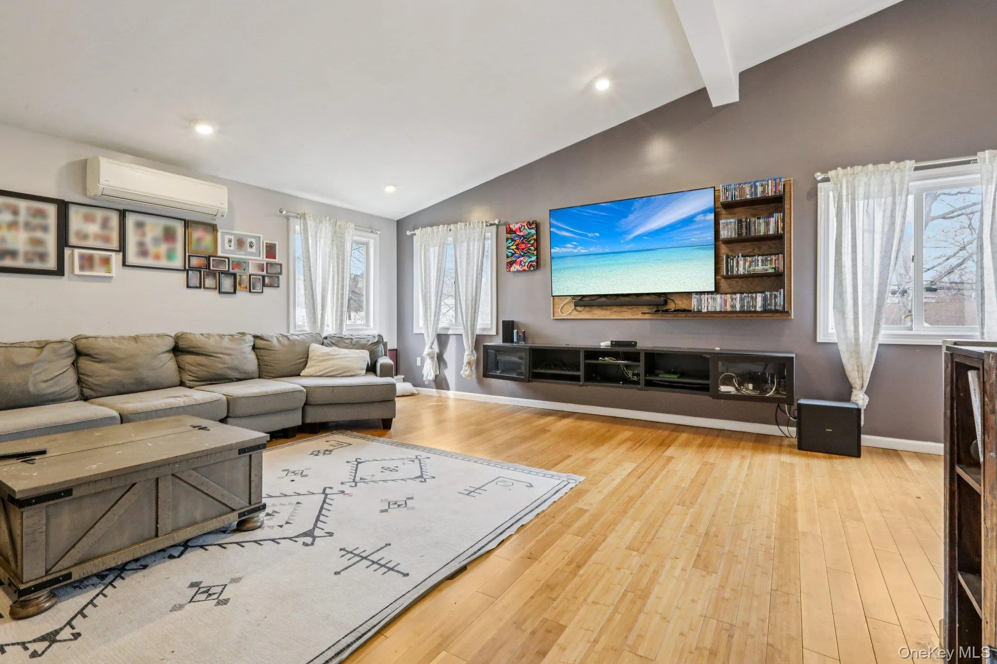 Living area with light wood-type flooring, recessed lighting, and vaulted ceiling with beams Living area with light wood-type flooring, recessed lighting, and vaulted ceiling with beams
