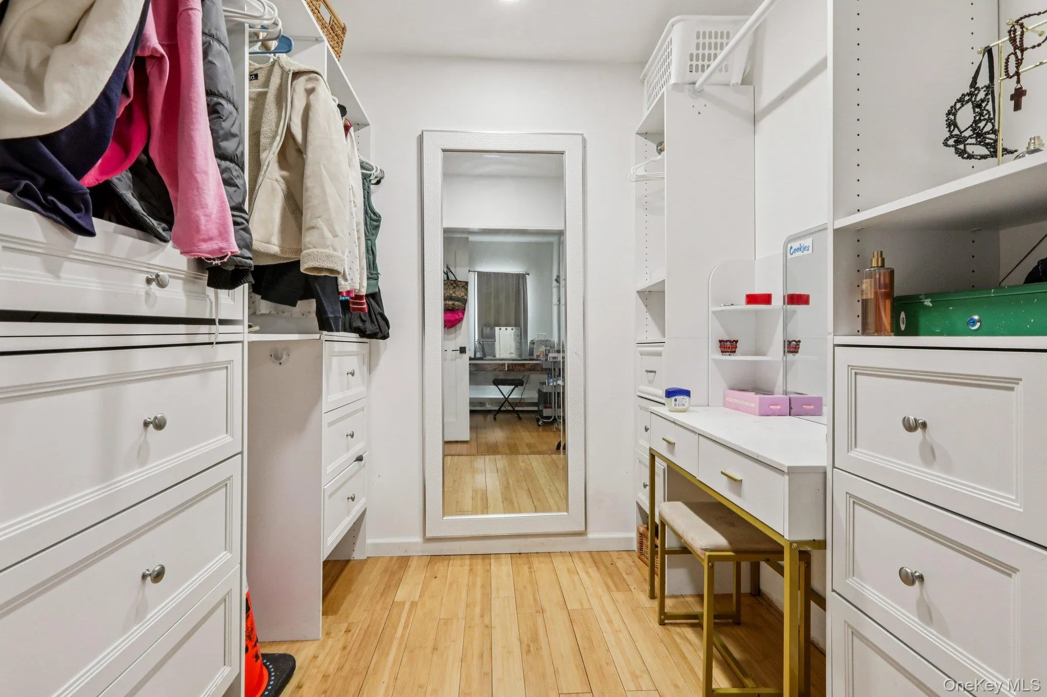 Walk in closet with light wood-style flooring Walk in closet with light wood-style flooring