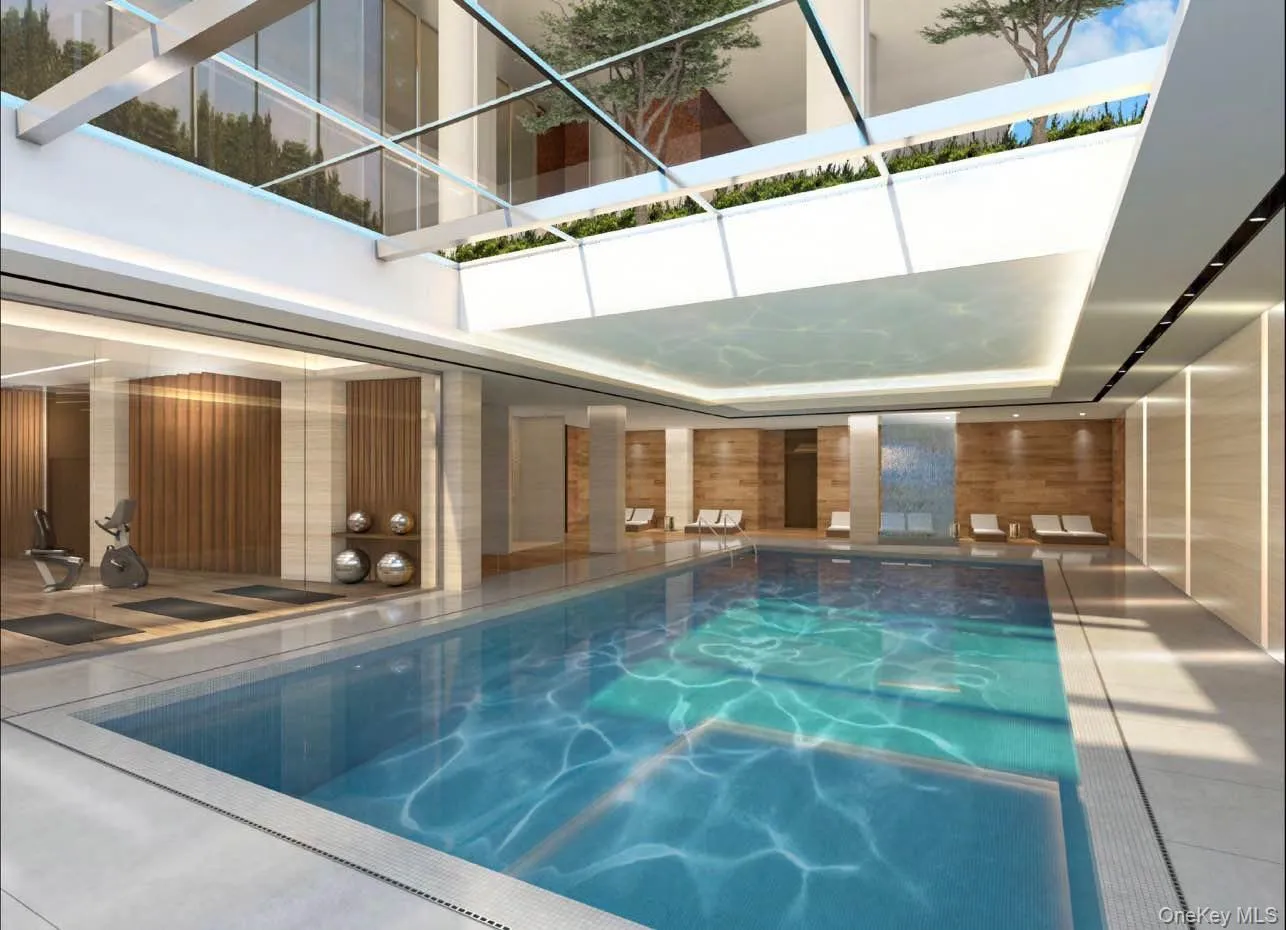 Indoor pool featuring glass enclosure and a patio area Indoor pool featuring glass enclosure and a patio area