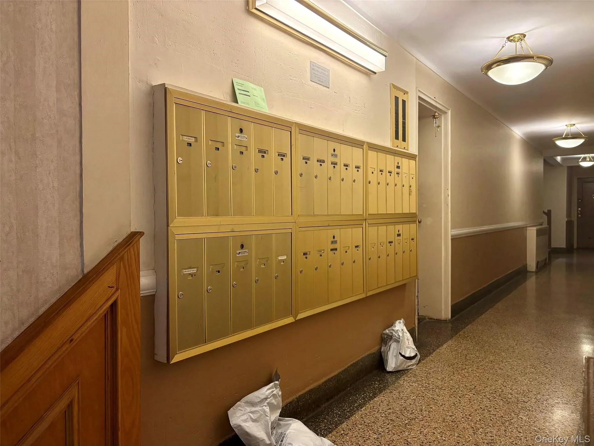 Hall featuring mail area and light aggregate flooring Hall featuring mail area and light aggregate flooring