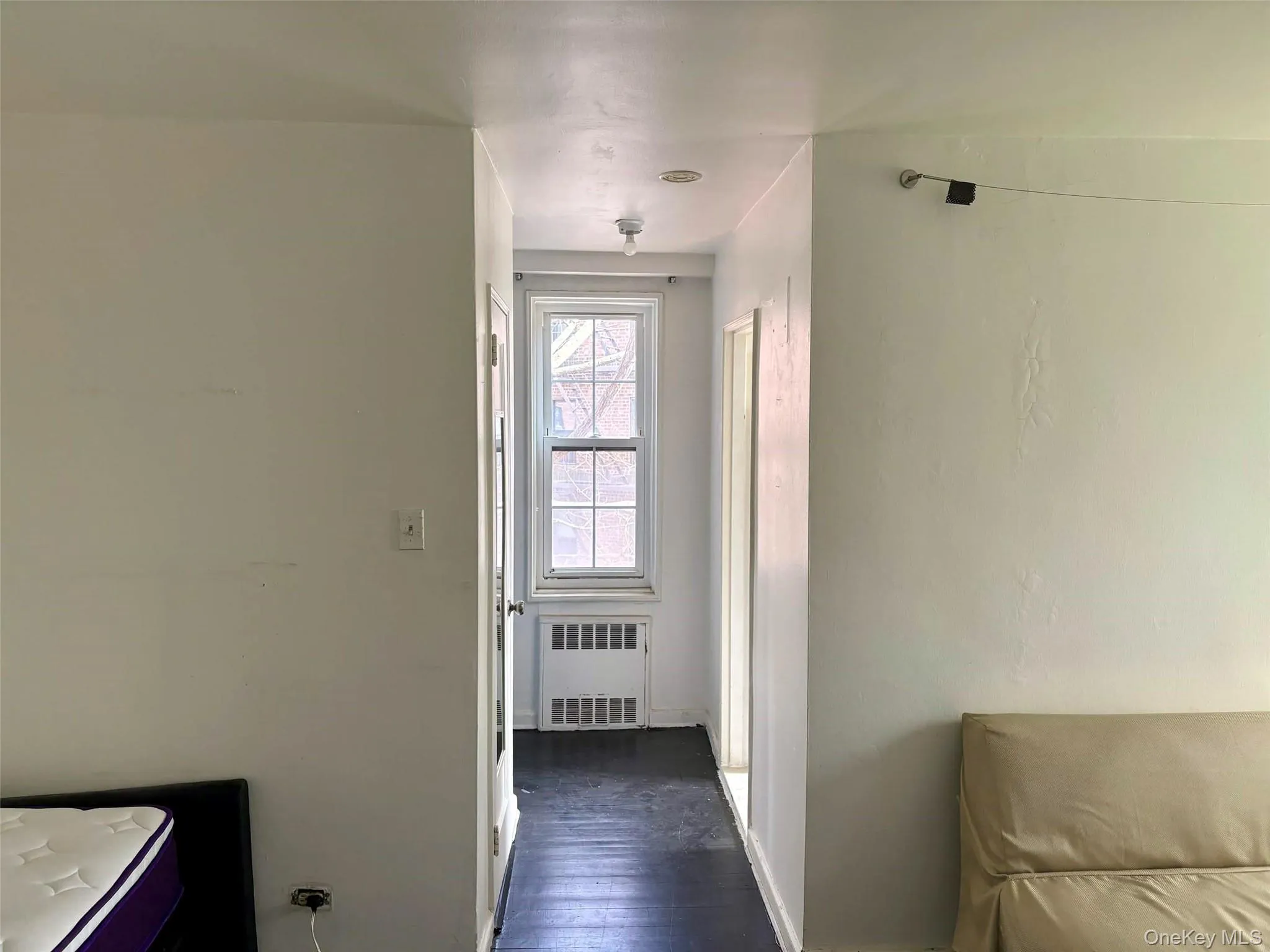 Hallway featuring radiator and dark wood-style floors Hallway featuring radiator and dark wood-style floors