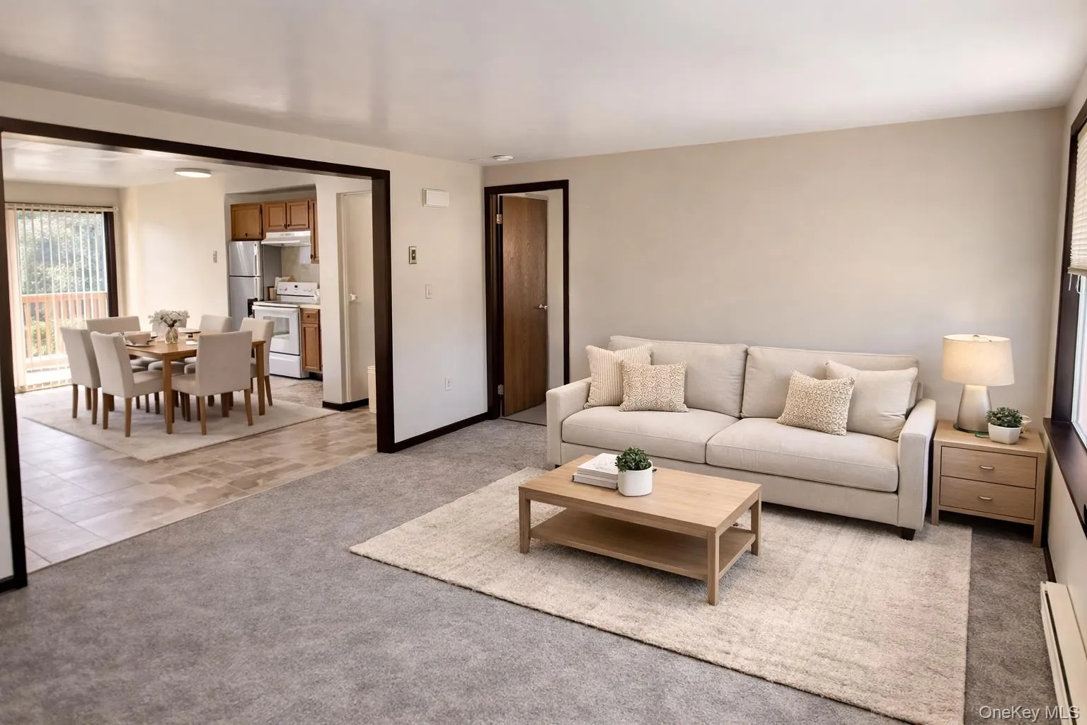 Living area featuring light colored carpet and a baseboard radiator Living area featuring light colored carpet and a baseboard radiator