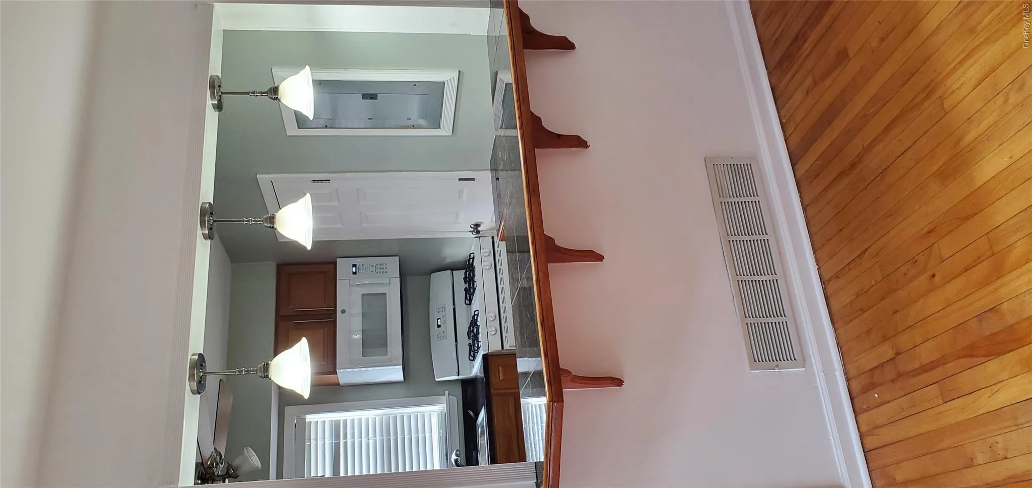 Kitchen with a kitchen bar, light hardwood / wood-style flooring, range, electric panel, and hanging light fixtures Kitchen with a kitchen bar, light hardwood / wood-style flooring, range, electric panel, and hanging light fixtures