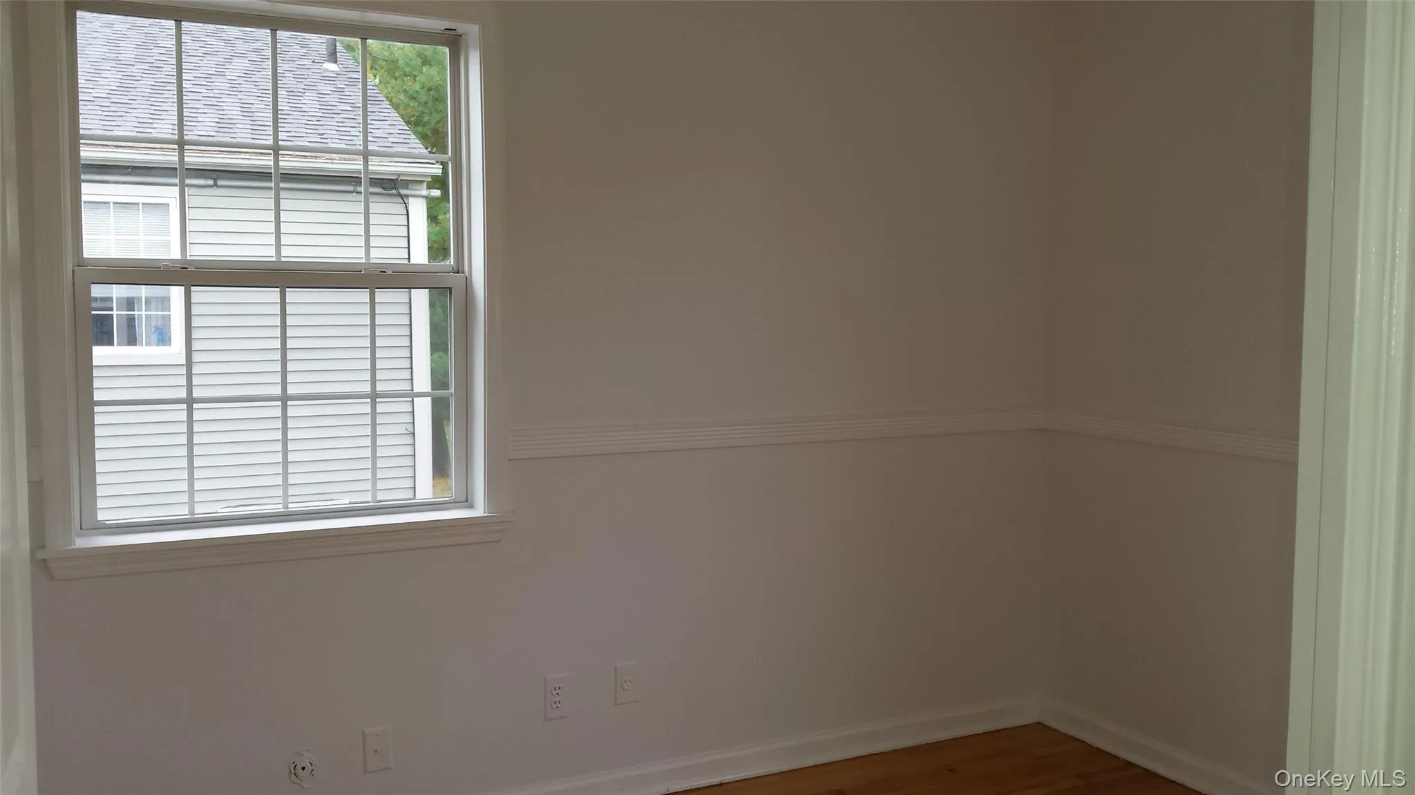Unfurnished room featuring hardwood / wood-style floors Unfurnished room featuring hardwood / wood-style floors