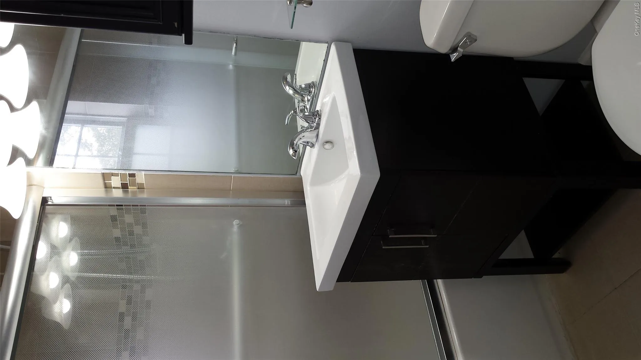 Full bathroom featuring tile patterned floors, vanity, toilet, and combined bath / shower with glass door Full bathroom featuring tile patterned floors, vanity, toilet, and combined bath / shower with glass door