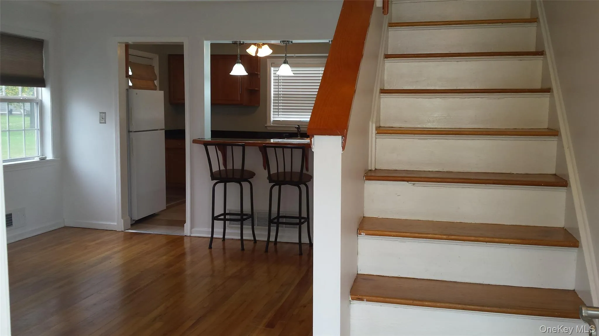 Stairs featuring wood-type flooring and sink Stairs featuring wood-type flooring and sink