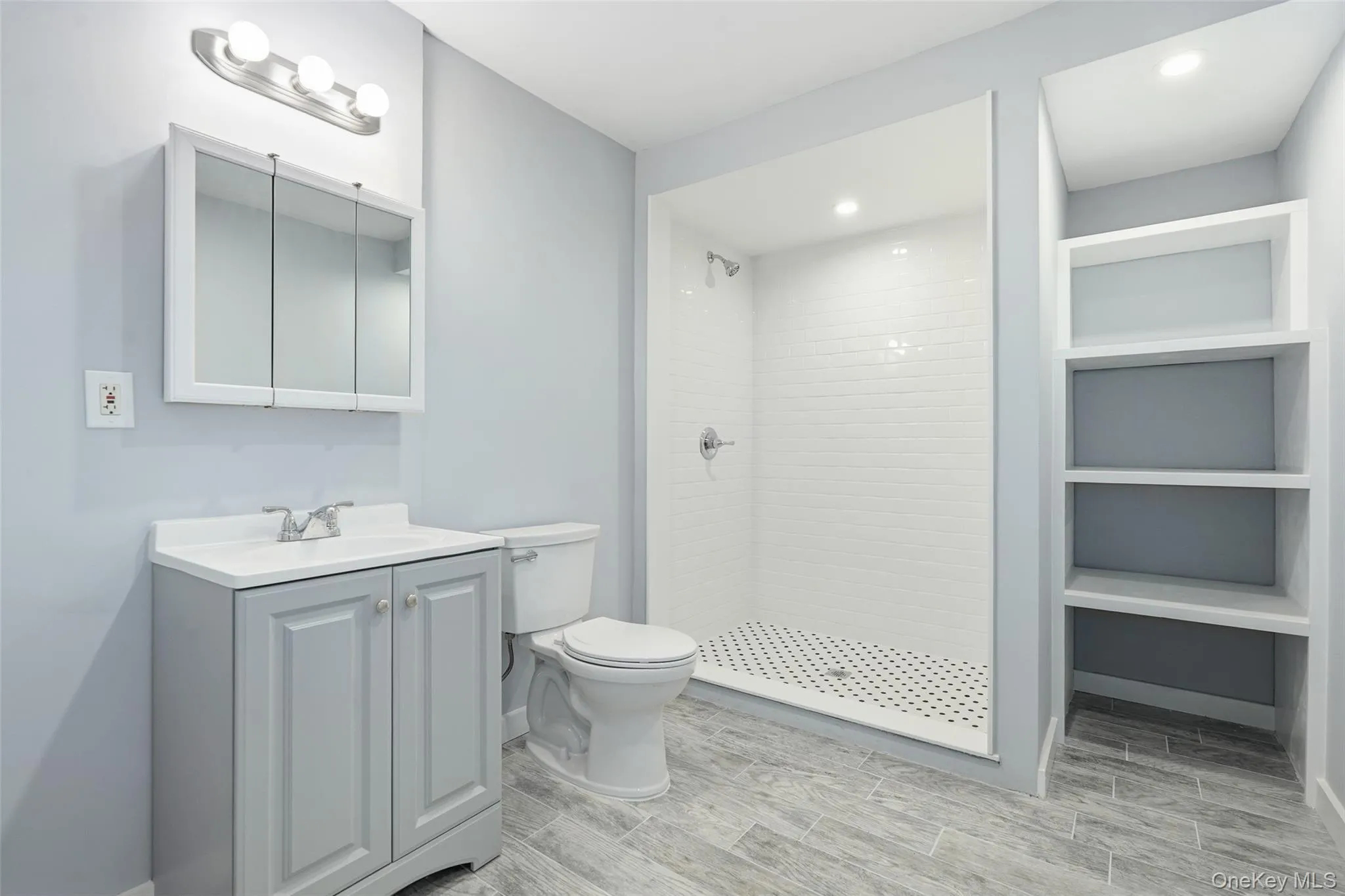 Renovated Bathroom with vanity, a shower stall, recessed lighting, wood tiled floors, and built in features Renovated Bathroom with vanity, a shower stall, recessed lighting, wood tiled floors, and built in features
