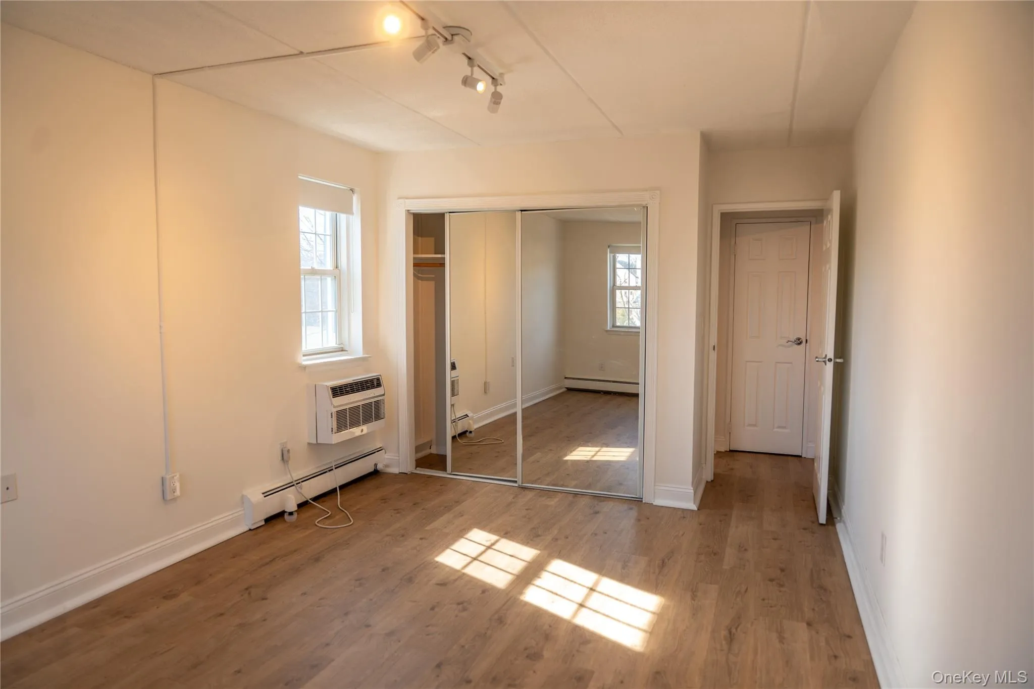 A view of the bedroom showing Southern exposure overlooking the park, new flooring, new lighting and a double closet A view of the bedroom showing Southern exposure overlooking the park, new flooring, new lighting and a double closet