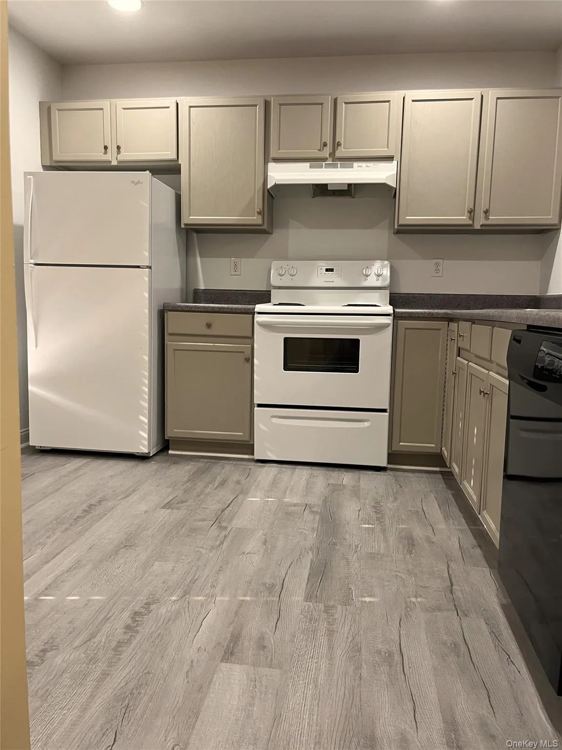 Kitchen featuring gray cabinets, dark countertops, white appliances, light wood-style floors, and recessed lighting Kitchen featuring gray cabinets, dark countertops, white appliances, light wood-style floors, and recessed lighting
