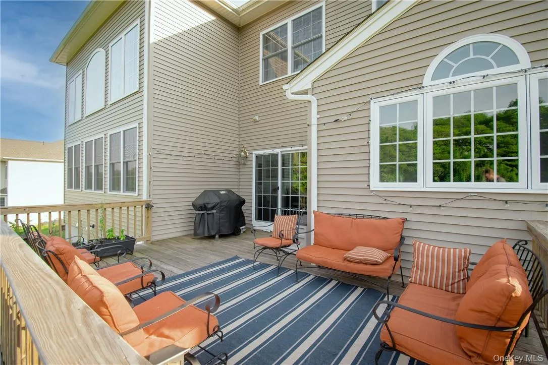 Deck with an outdoor living space and a grill Deck with an outdoor living space and a grill