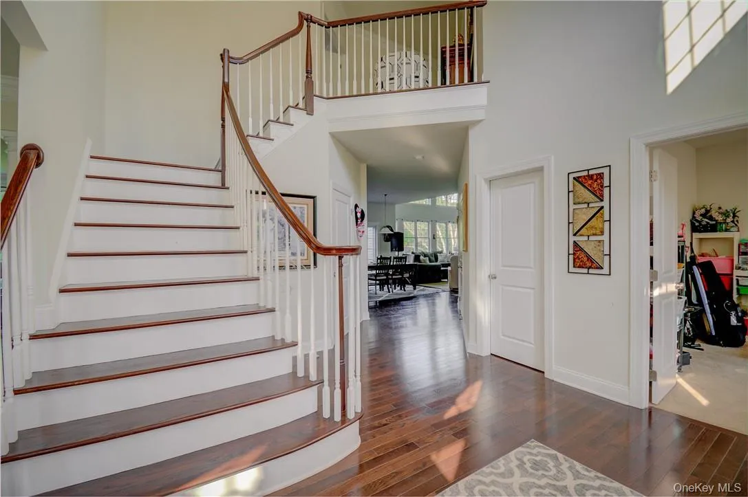 Stairway featuring a towering ceiling and dark hardwood / wood-style flooring Stairway featuring a towering ceiling and dark hardwood / wood-style flooring