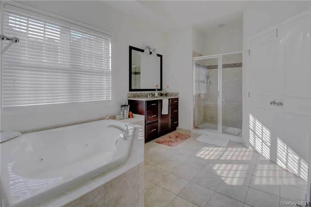 Master Bathroom featuring tile flooring, independent shower and bath, and large vanity Master Bathroom featuring tile flooring, independent shower and bath, and large vanity
