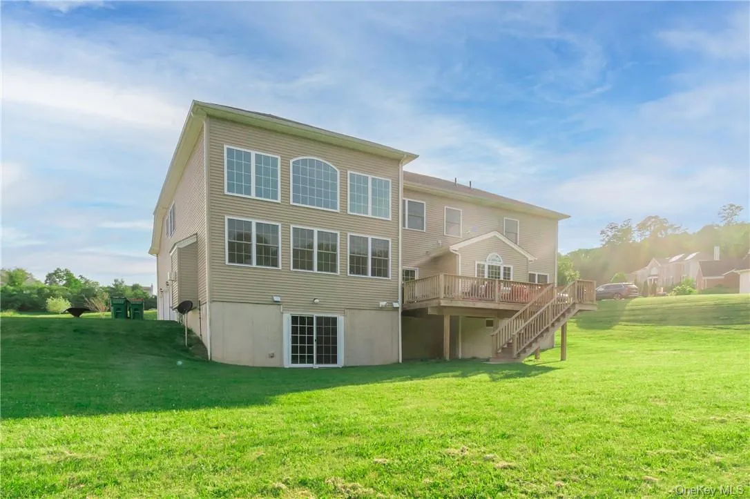 Rear view of property with a yard and a deck Rear view of property with a yard and a deck