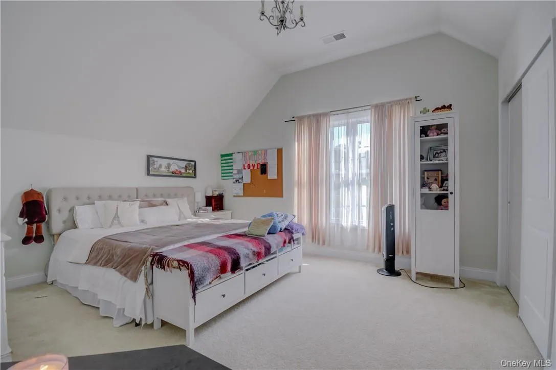 Carpeted Jack and Jill bedroom with lofted ceiling and an inviting chandelier Carpeted Jack and Jill bedroom with lofted ceiling and an inviting chandelier