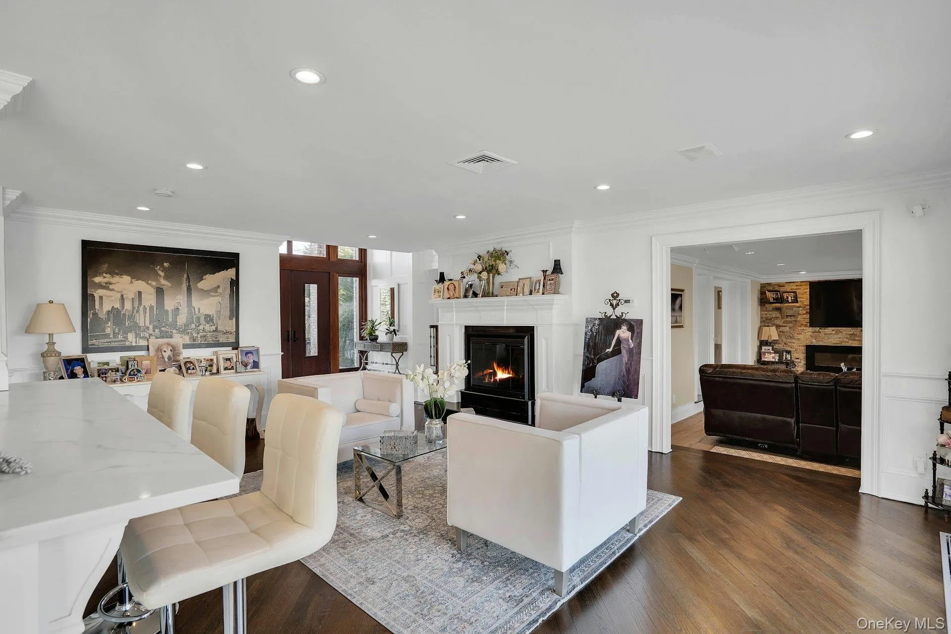 Hardwood flooring and open living with bar area overlooking kitchen. Hardwood flooring and open living with bar area overlooking kitchen.